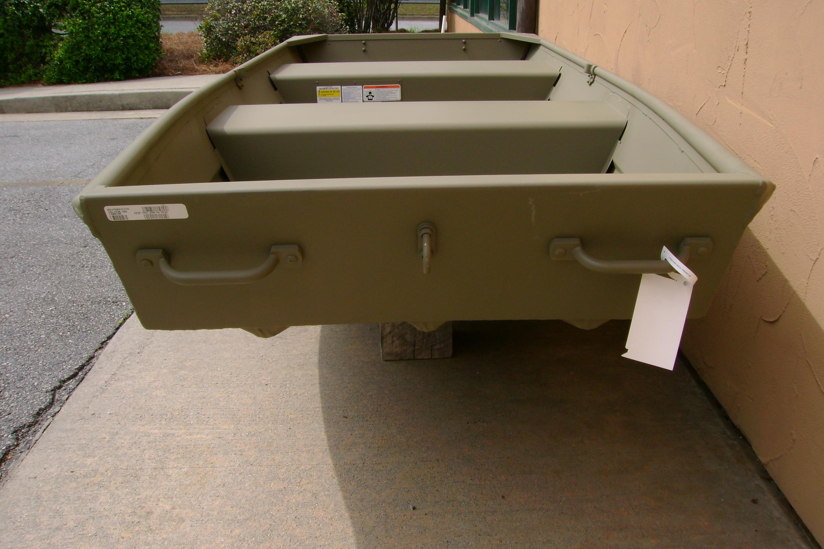 2026 Tracker Grizzly 12 Jon boat in olive green, displayed outdoors on concrete.