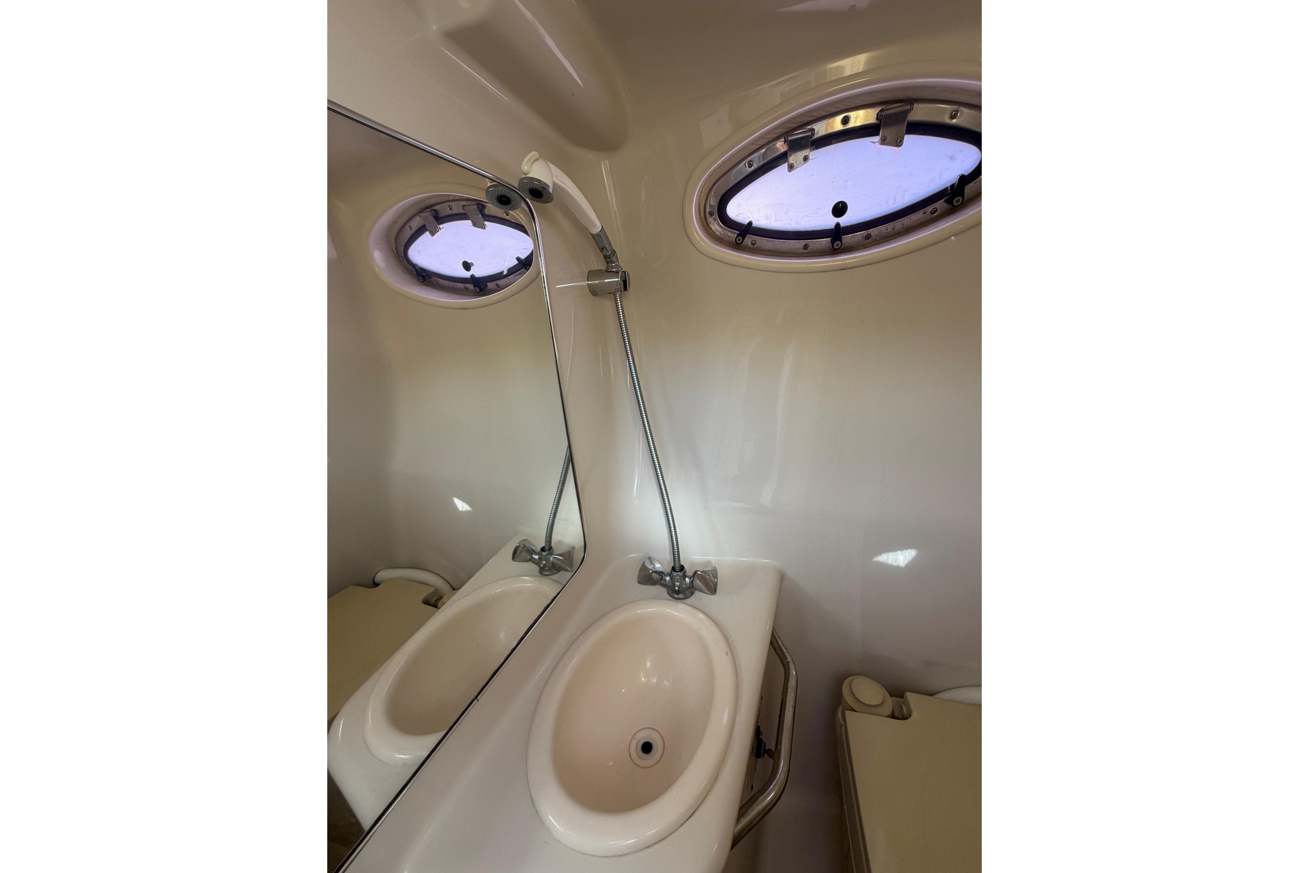 A sleek bathroom with a sink and porthole window on a boat.