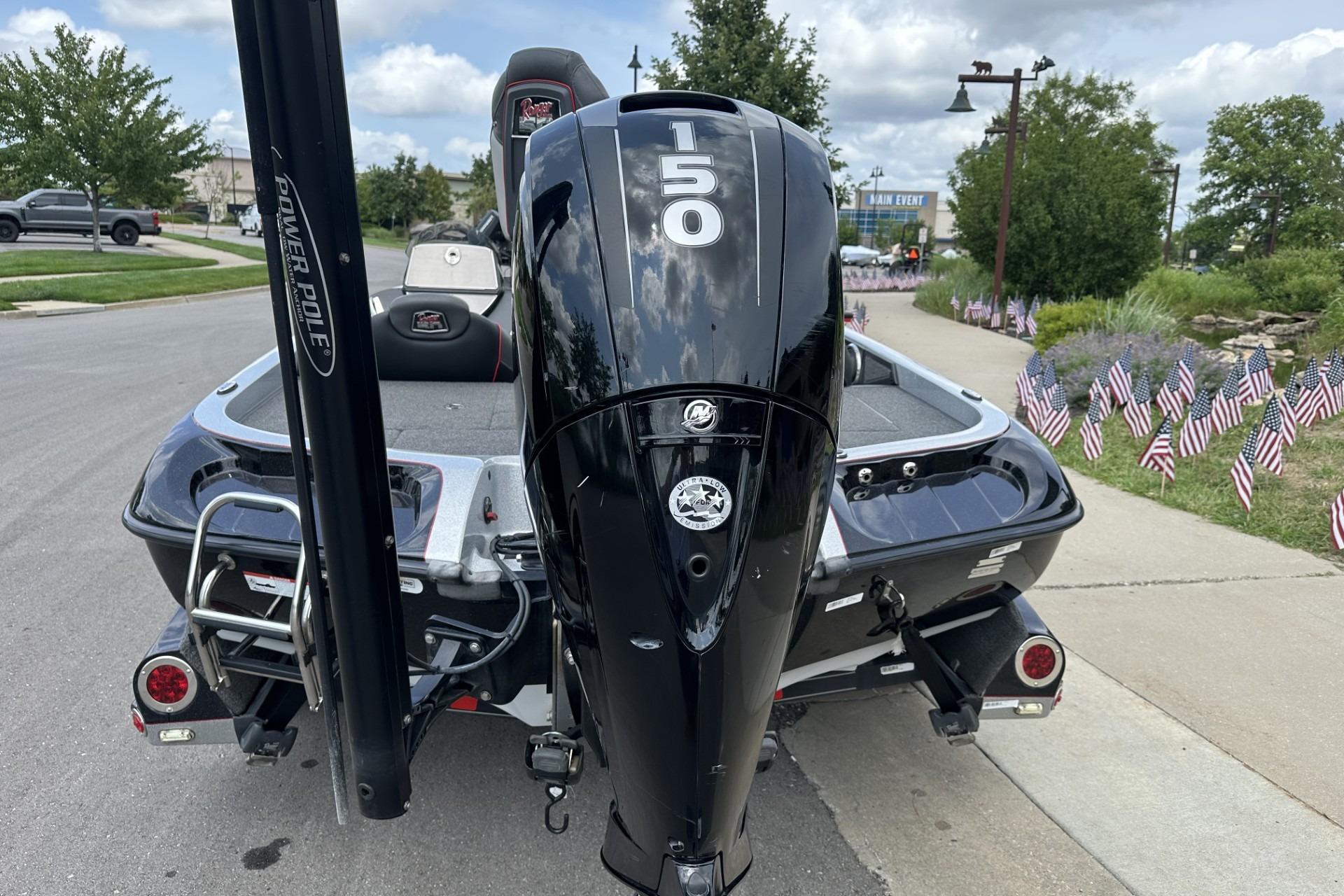 2018 Ranger Z518 boat with 150 HP engine, parked on a street with American flags.