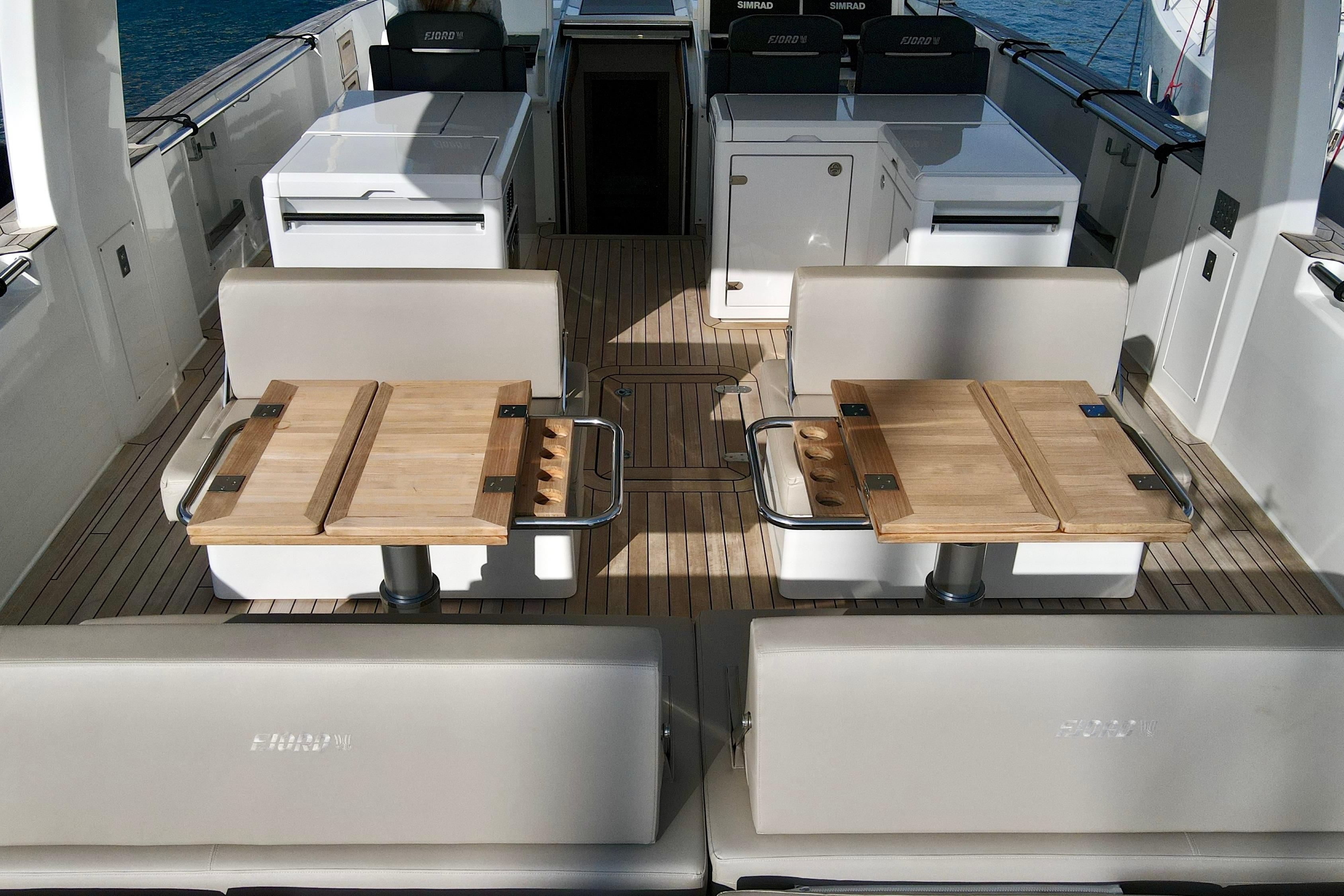 Luxurious 2023 Fjord 53 XL yacht interior with elegant seating and wooden tables.