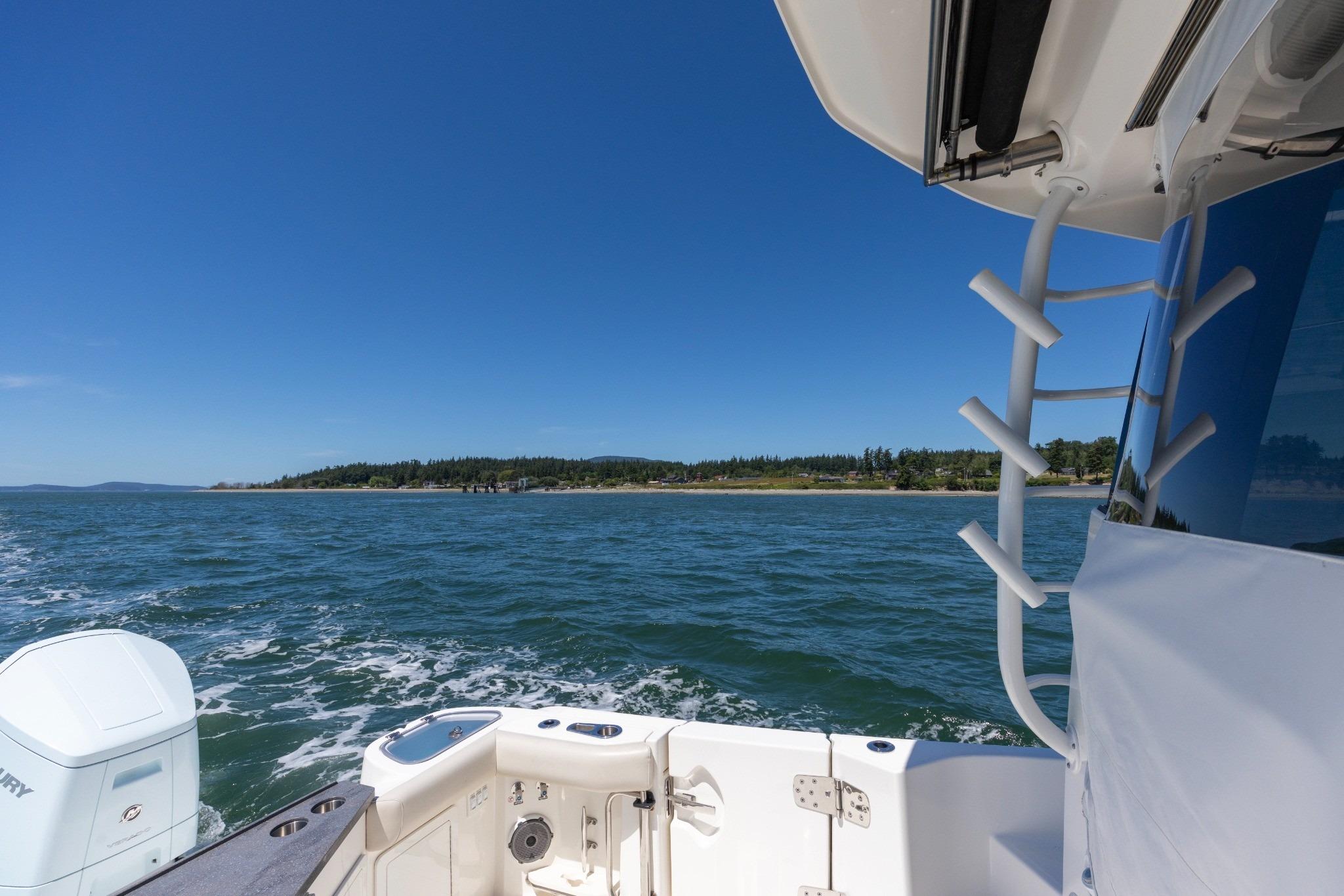 2023 Boston Whaler 405 Conquest cruising on open water under clear blue skies.