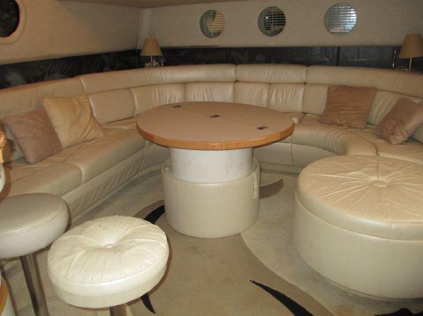 Luxurious interior of a 1994 Sea Ray 500 Sundancer yacht with plush seating and round table.