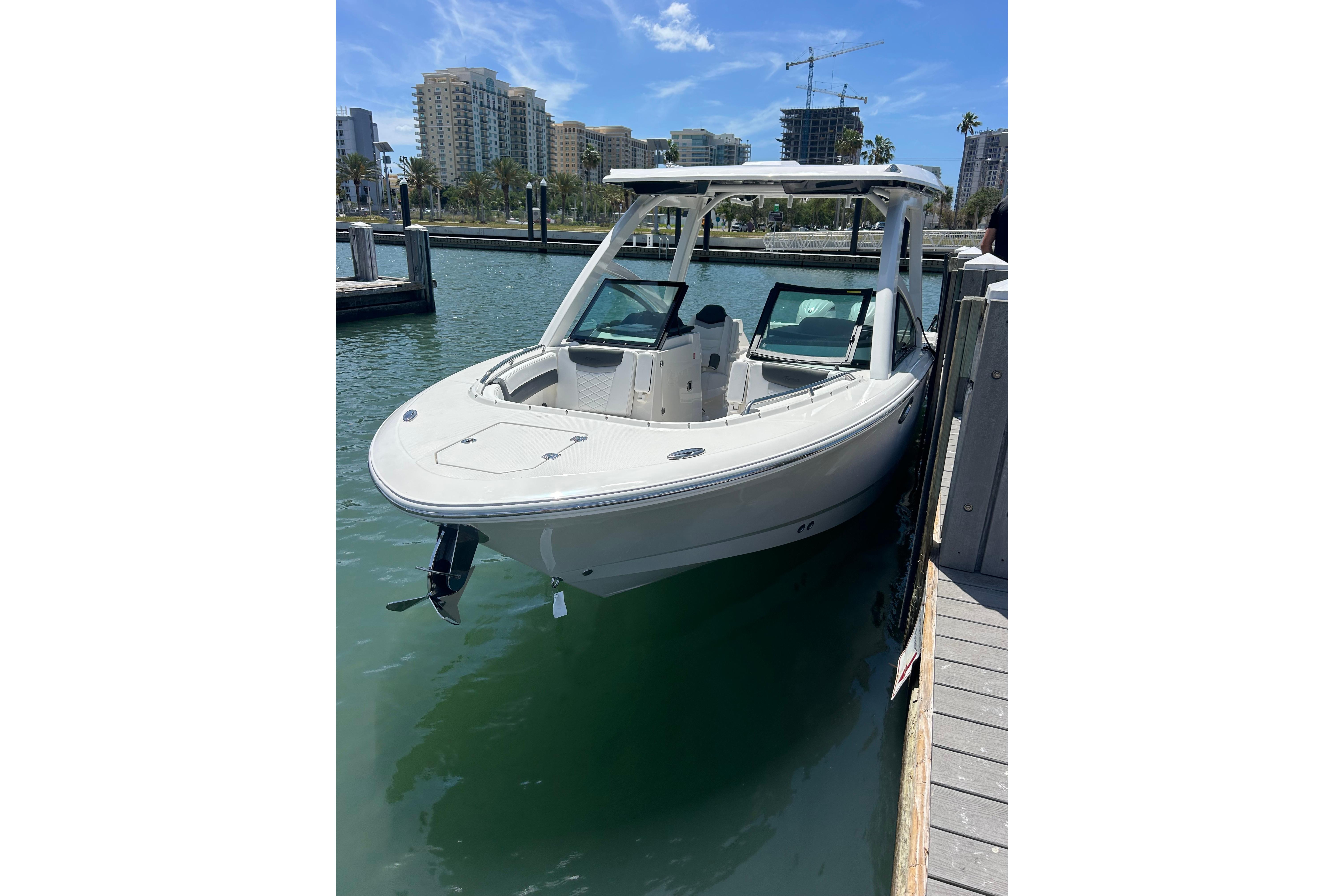 2026 Robalo R257 Dual Console boat docked in a marina with cityscape background.