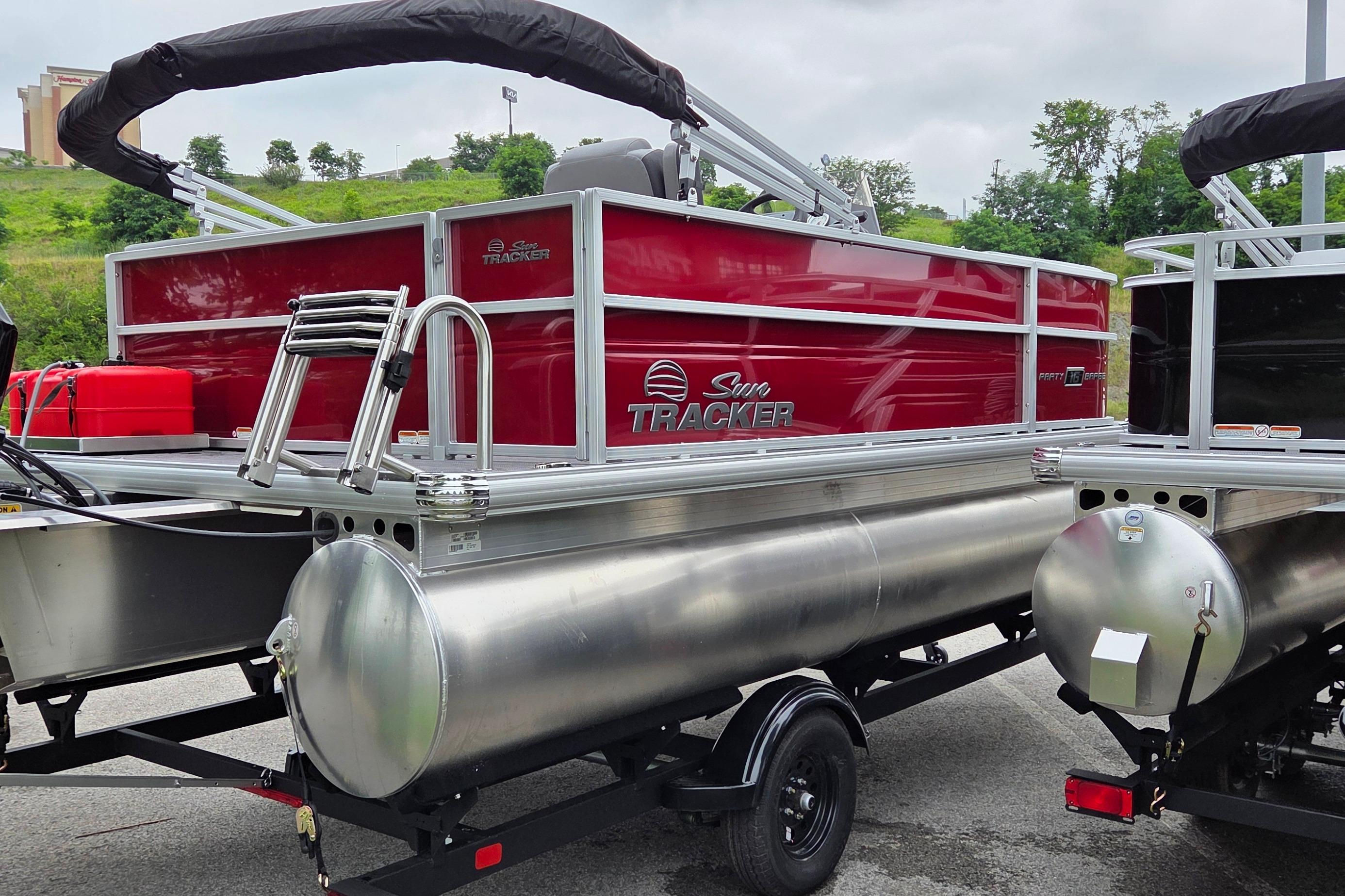 2026 Sun Tracker Party Barge 16 DLX pontoon boat with red exterior on trailer.
