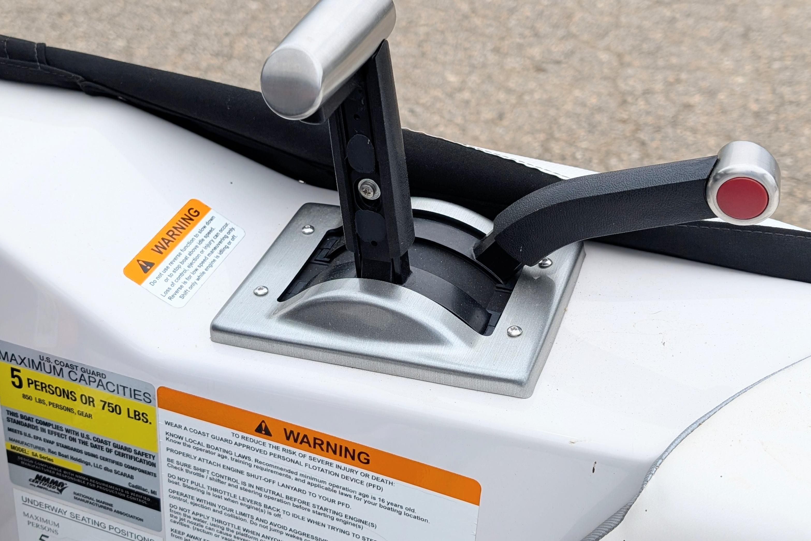 Throttle control of 2016 Scarab 165 ID boat with warning labels visible.