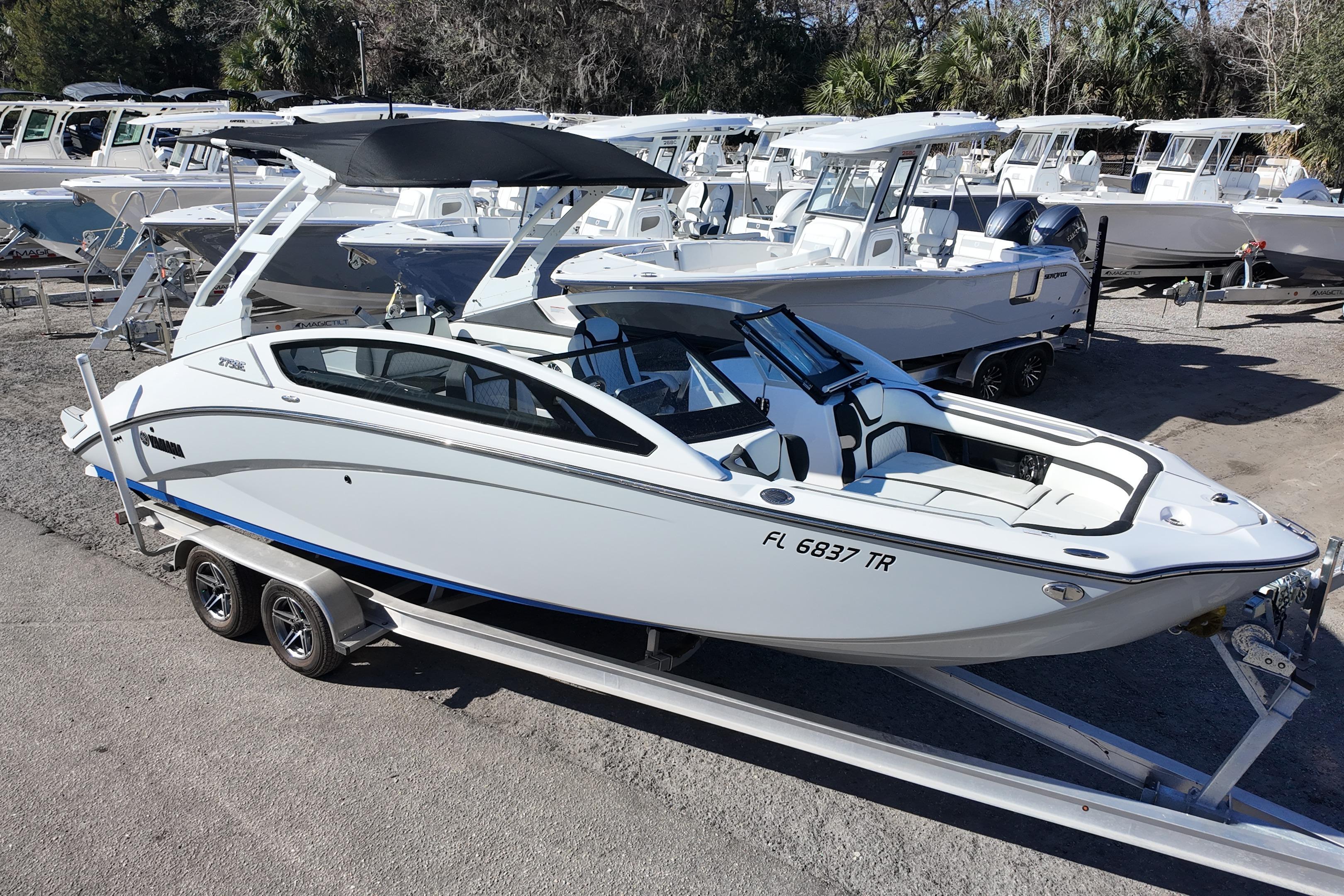 2024 Yamaha Boats 275SE on trailer, sleek design, parked outdoors.