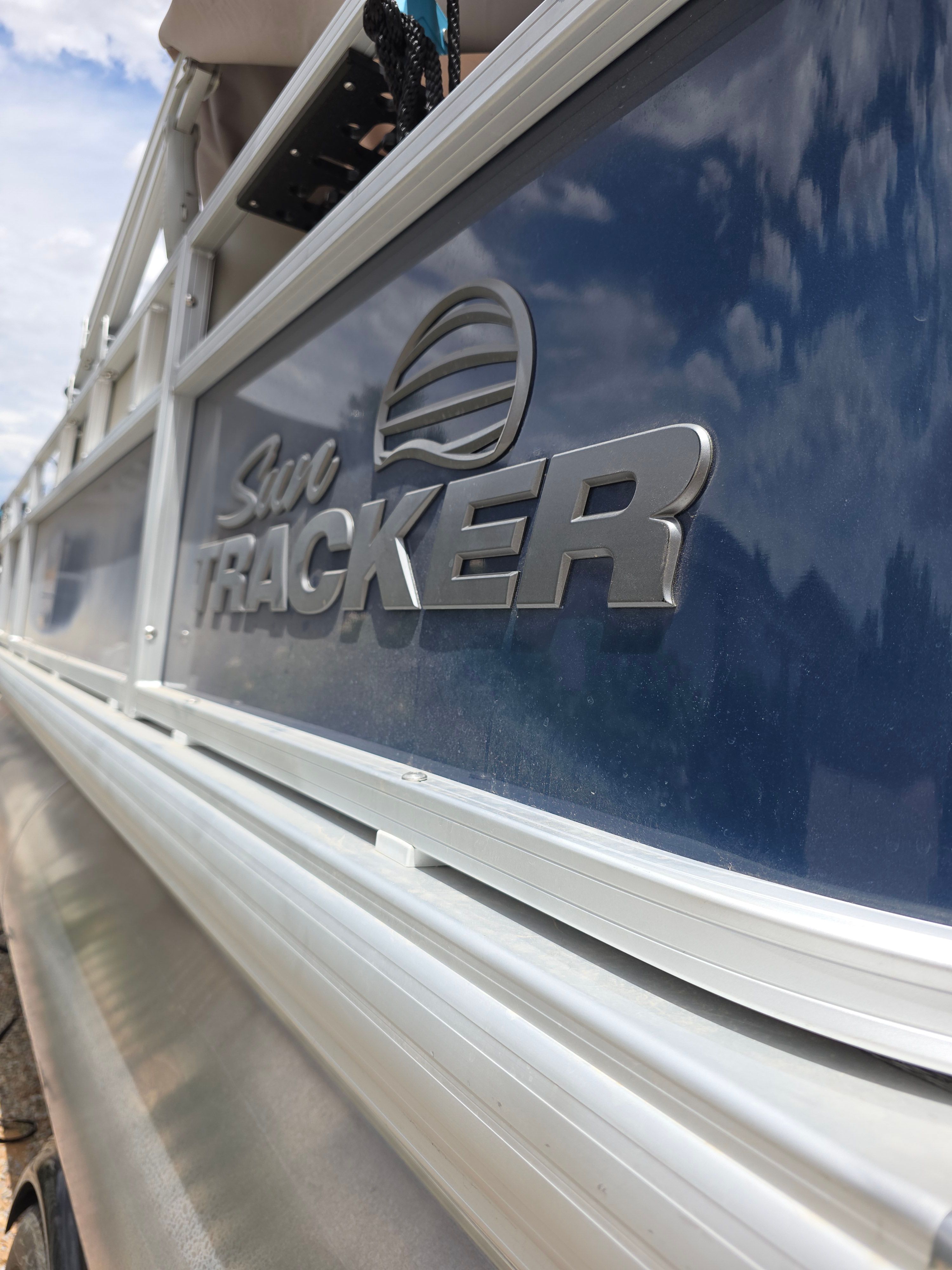 Close-up of the Sun Tracker Bass Buggy 18 DLX with blue hull and logo.