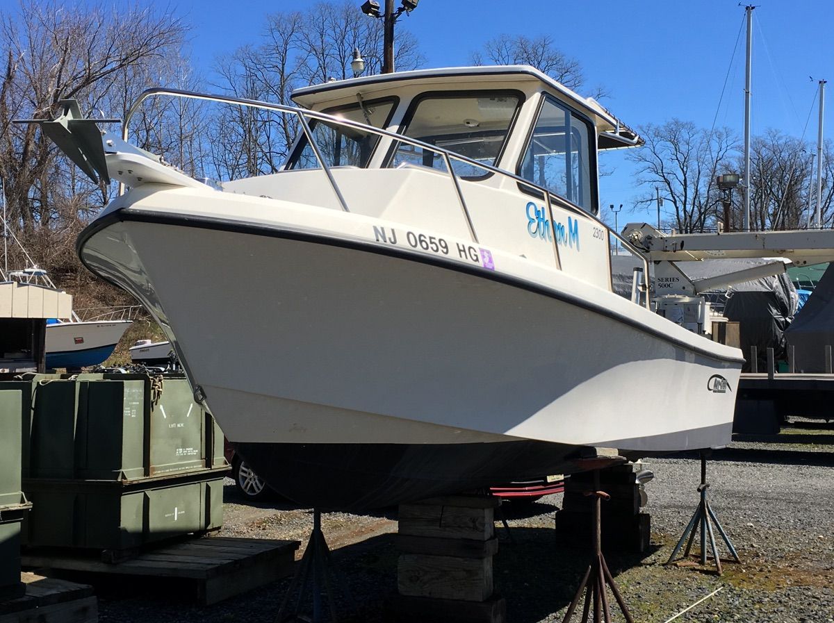 2015 May-Craft 2300 Pilot on stands, featuring a sturdy cabin and clear hull design.