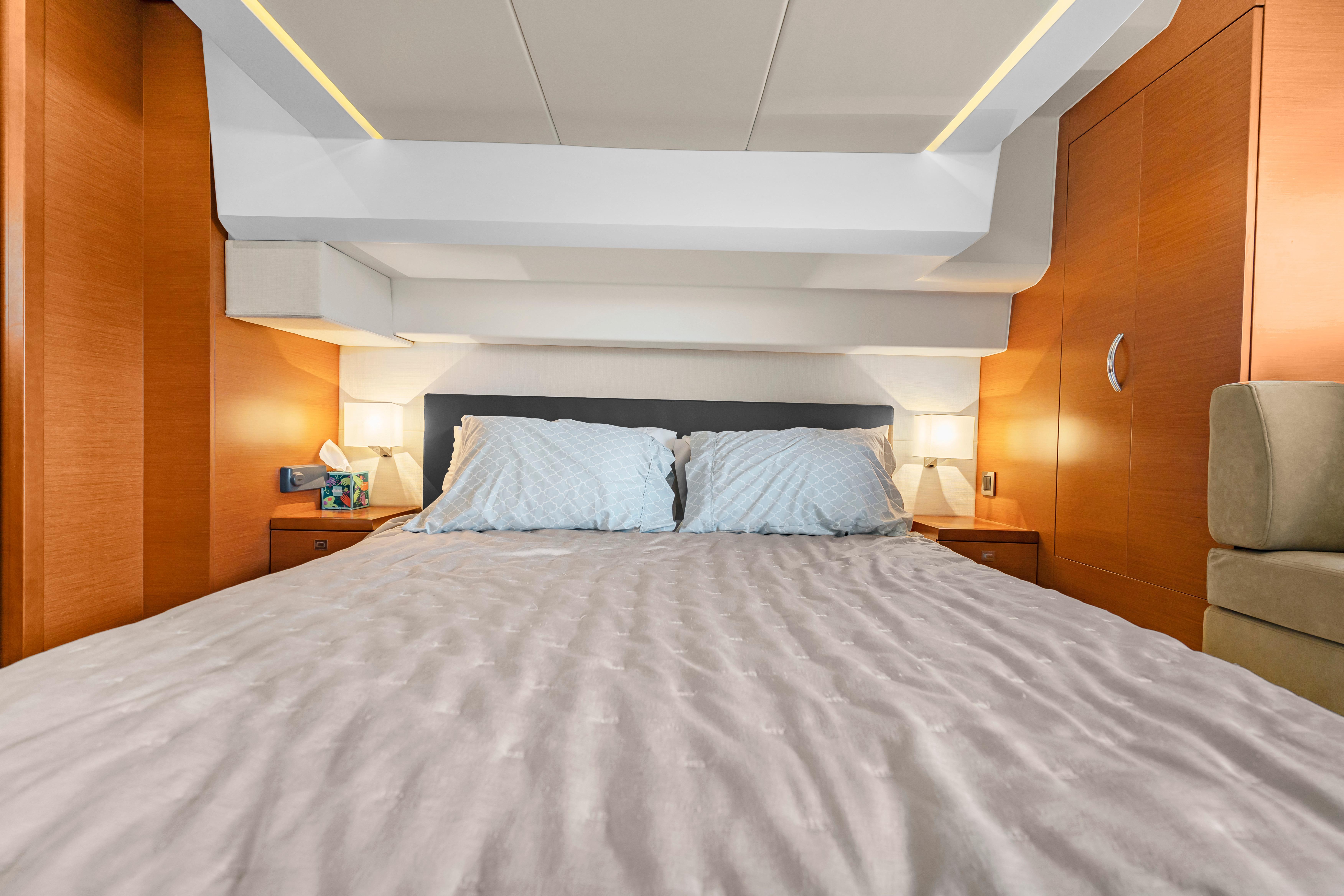 Luxurious cabin interior of 2017 Prestige 500 yacht with cozy bedding and ambient lighting.
