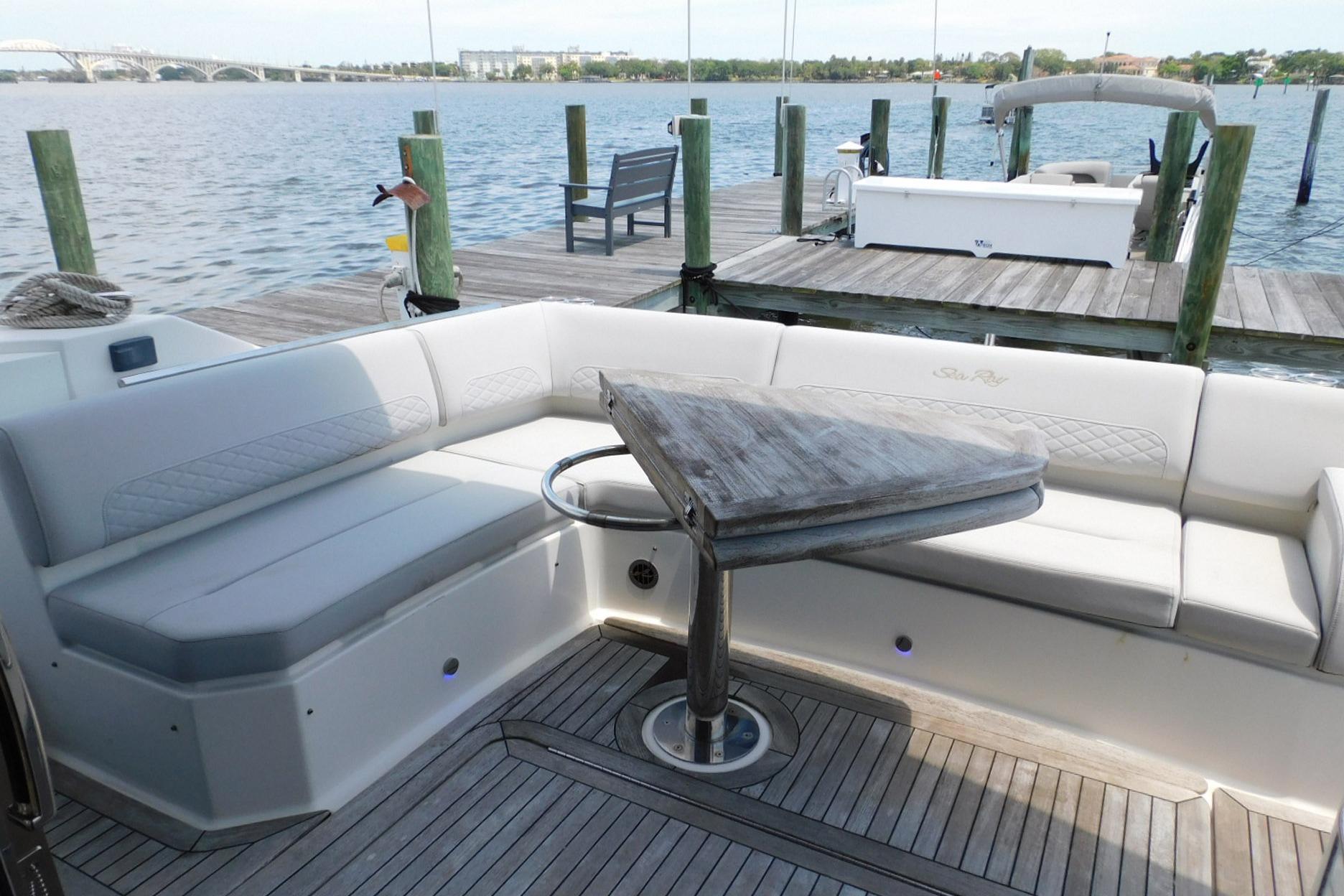 2019 Sea Ray L550 yacht with elegant seating and wooden table on deck.