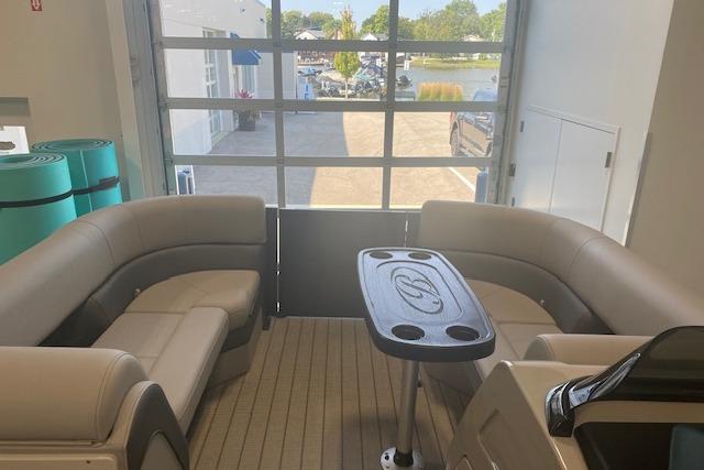 2026 Bentley Pontoons Elite 223 Swingback interior with seating and table, docked indoors.