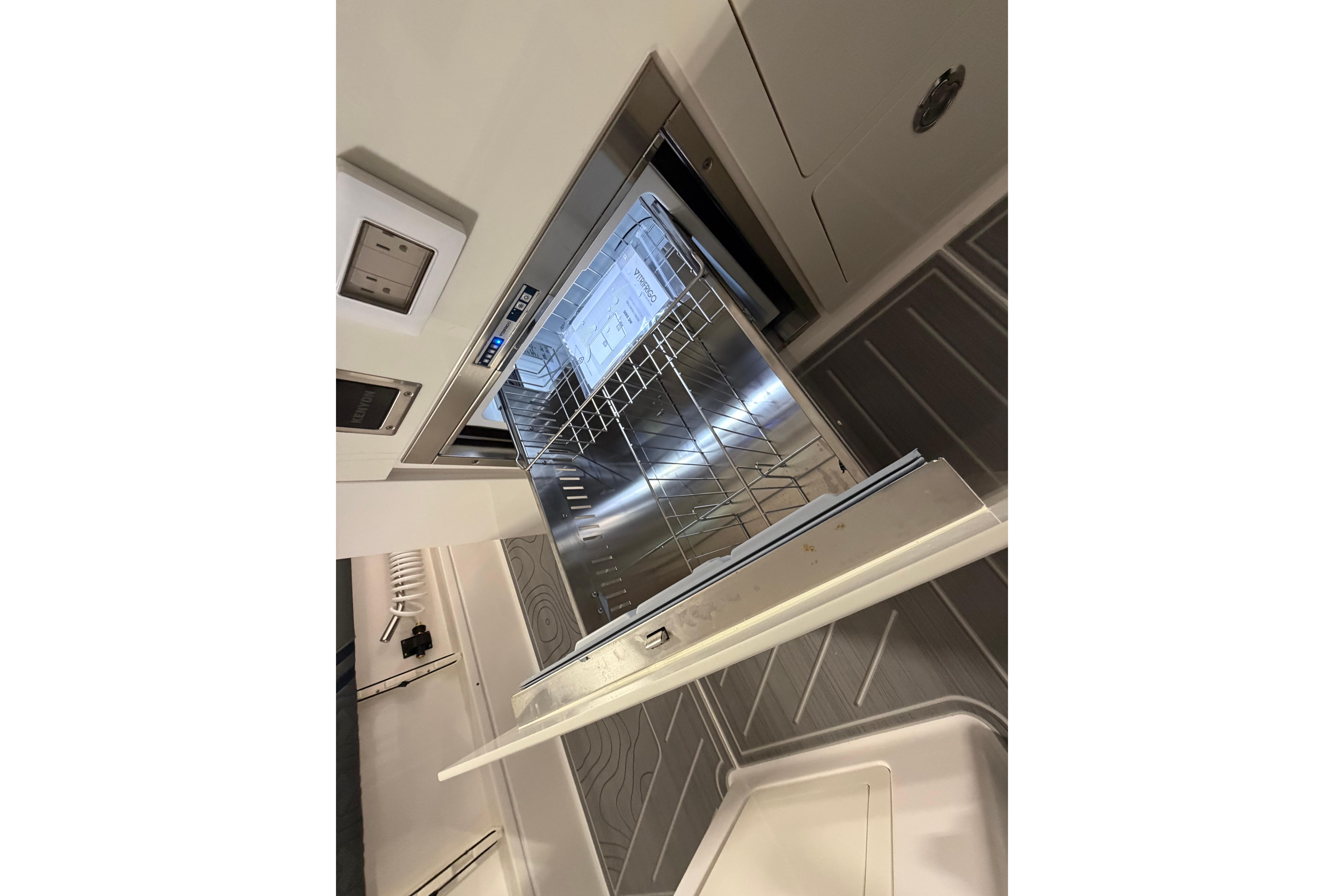 Open dishwasher inside a 2027 Regal 38 Surf boat kitchen area.