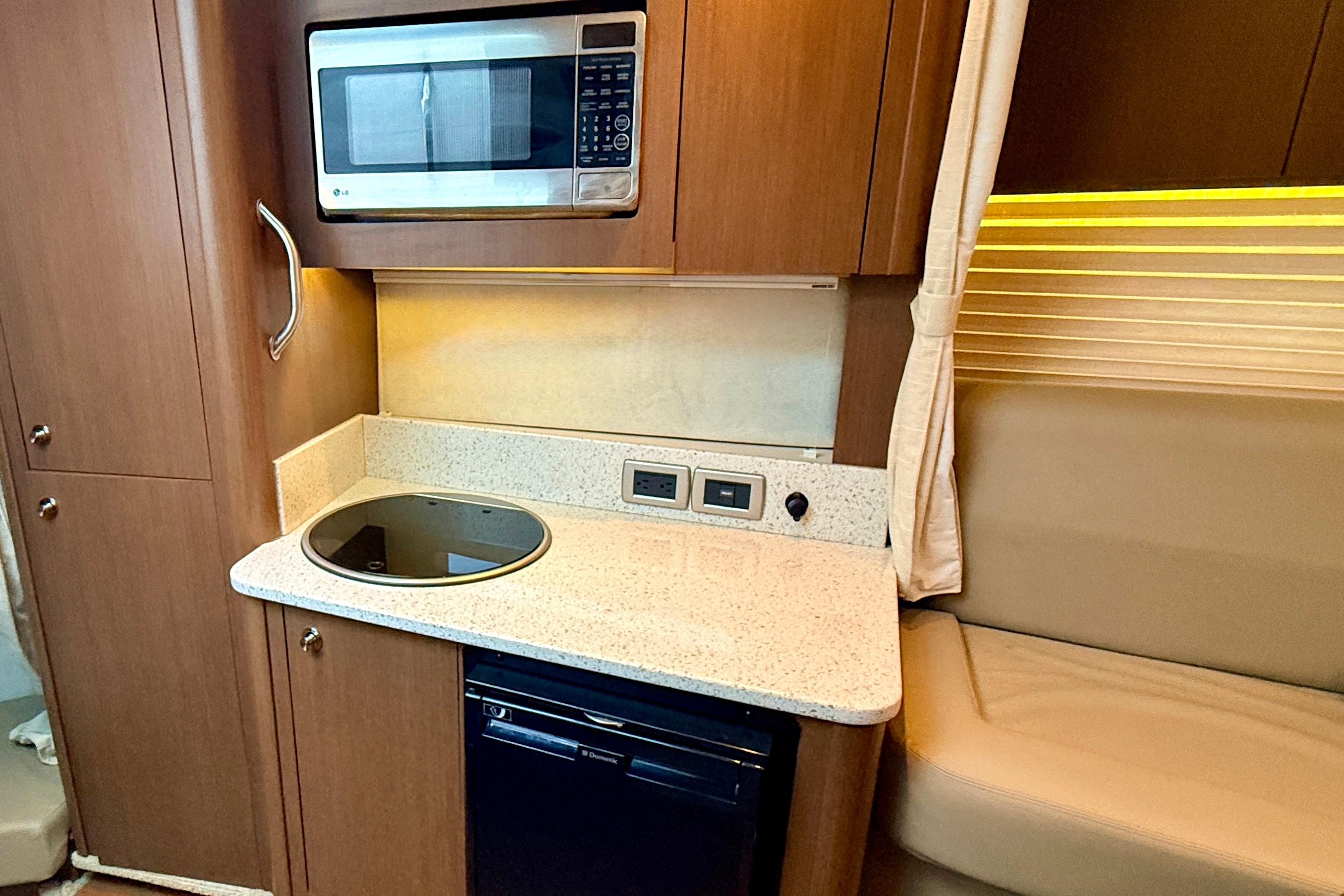 2013 Sea Ray 370 Venture galley with microwave, stovetop, and seating area.