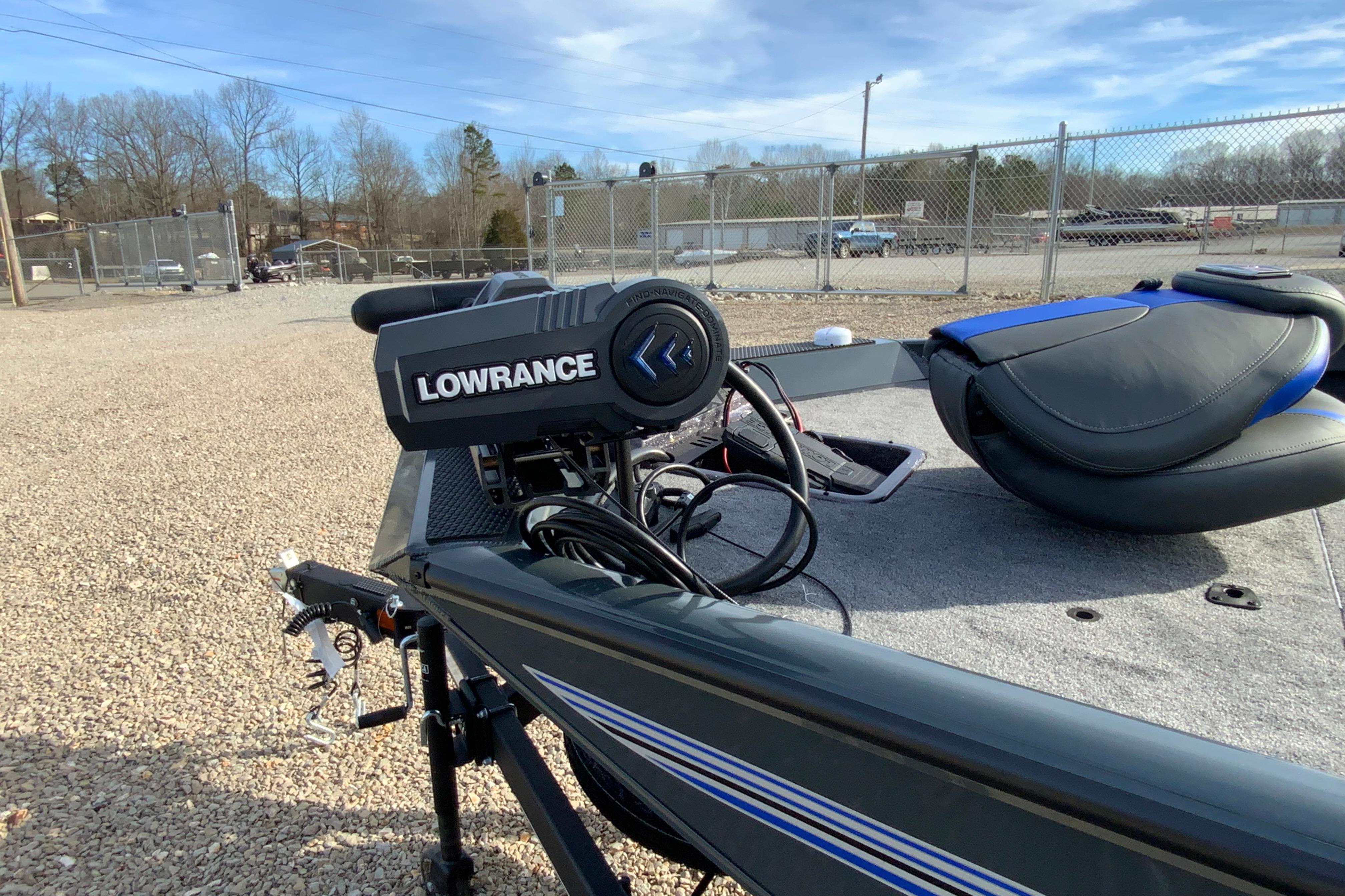 2026 Ranger RT198P boat with Lowrance equipment, parked on gravel near a fence.