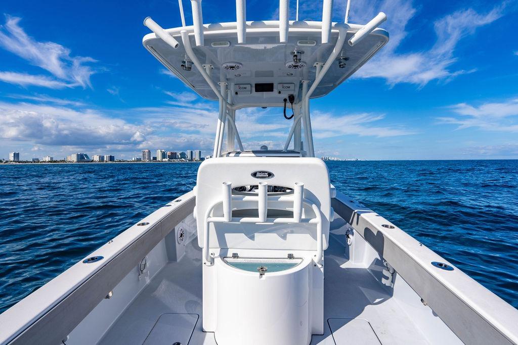 2024 Reef Runner 230 Open boat on ocean with city skyline in background.