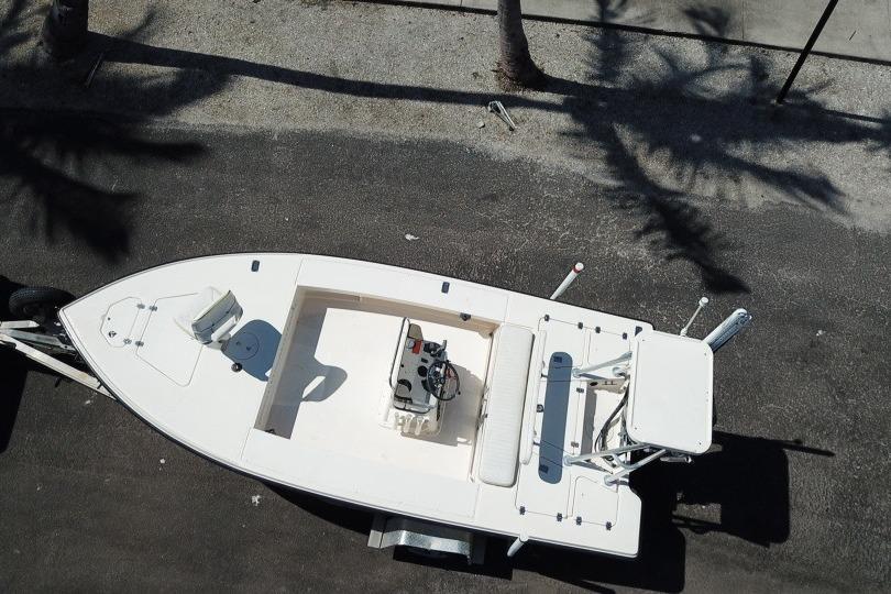 Aerial view of a 2002 Key West 1760 Stealth boat on a trailer, parked on asphalt.