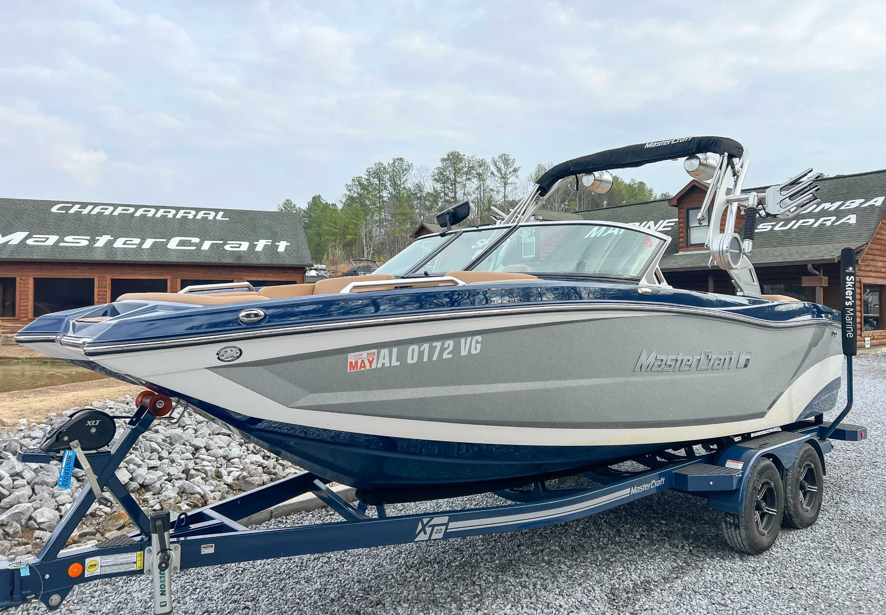 2021 MasterCraft XT22 boat on trailer in front of showroom.