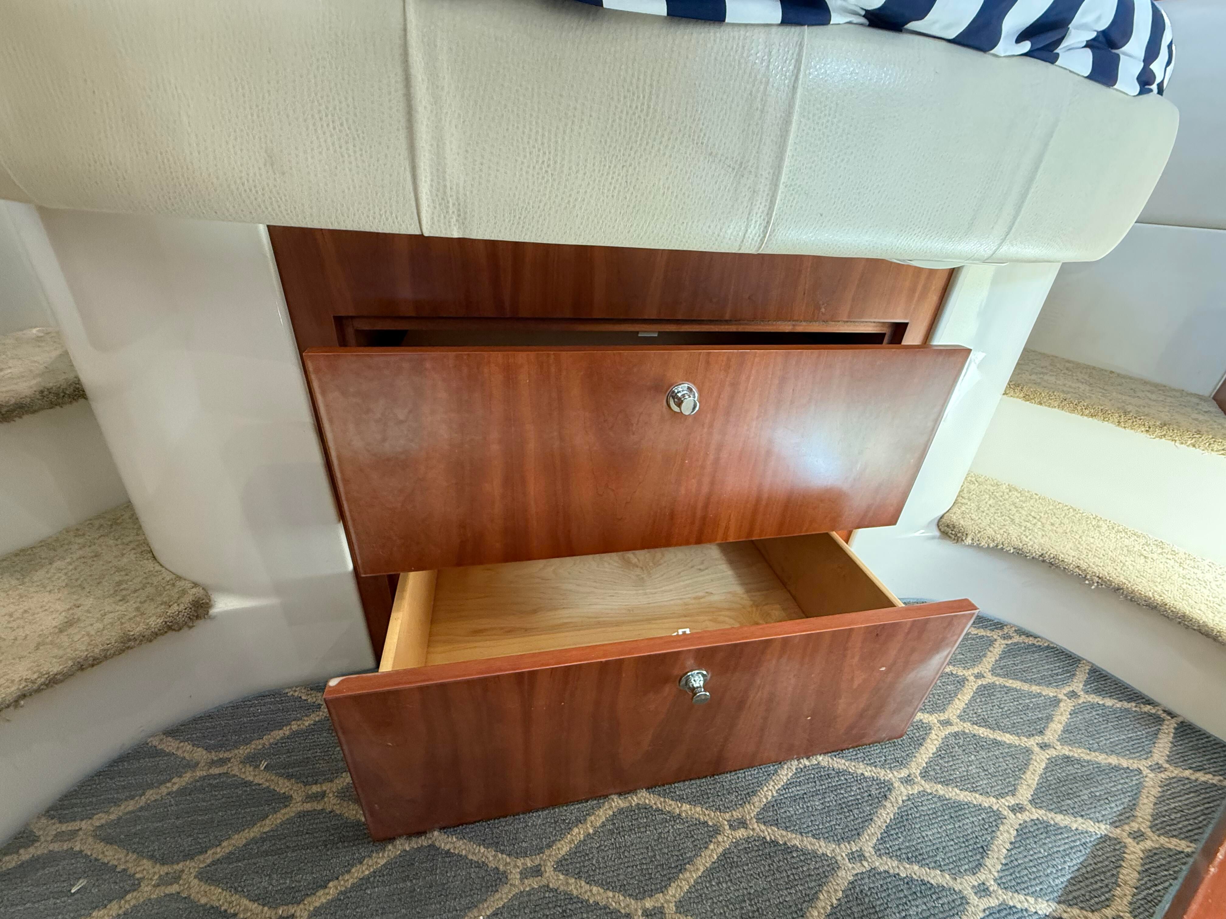Drawers beneath a cushioned bench seat inside a boat.