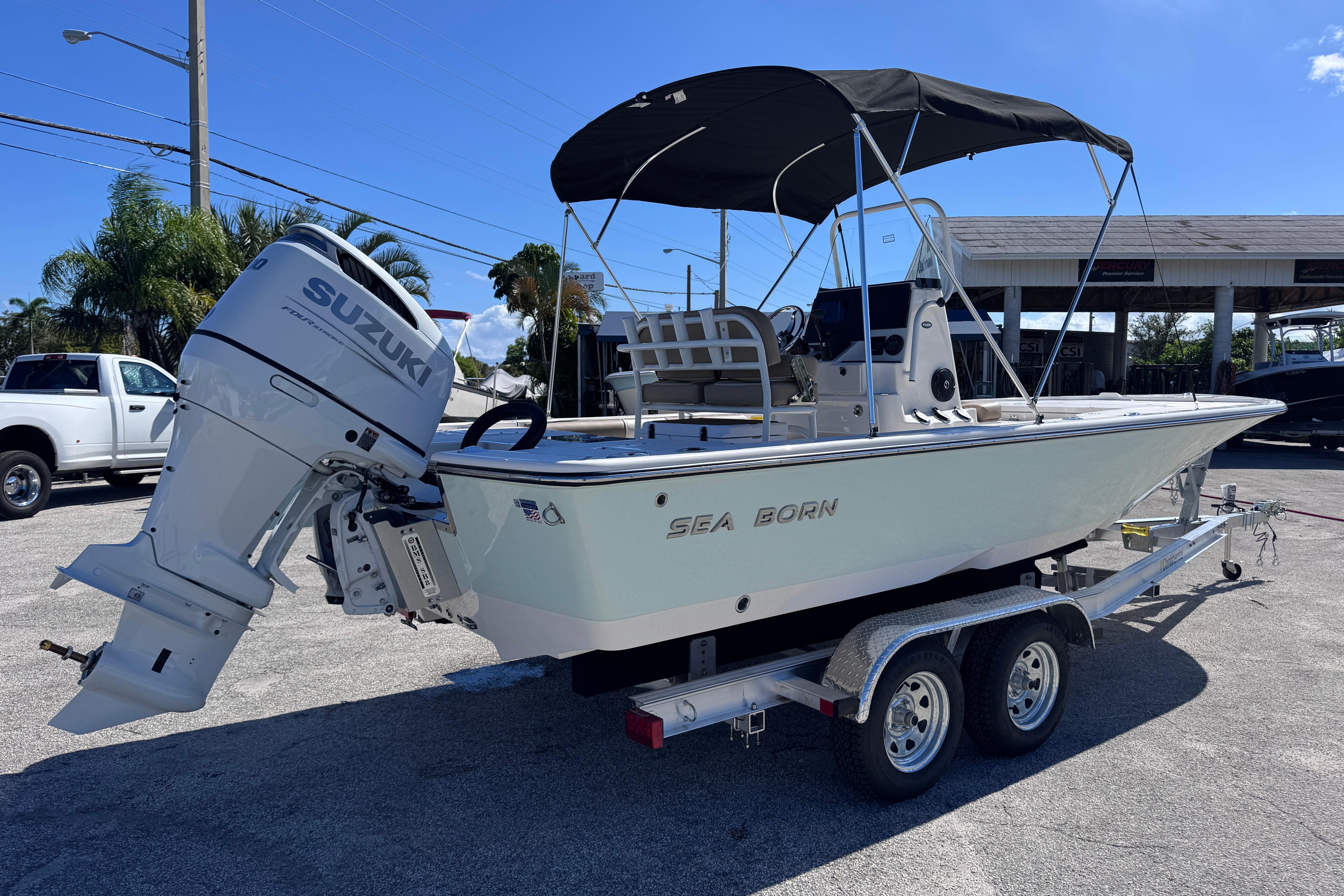 2026 Sea Born FX22 Bay boat on trailer with Suzuki outboard motor.