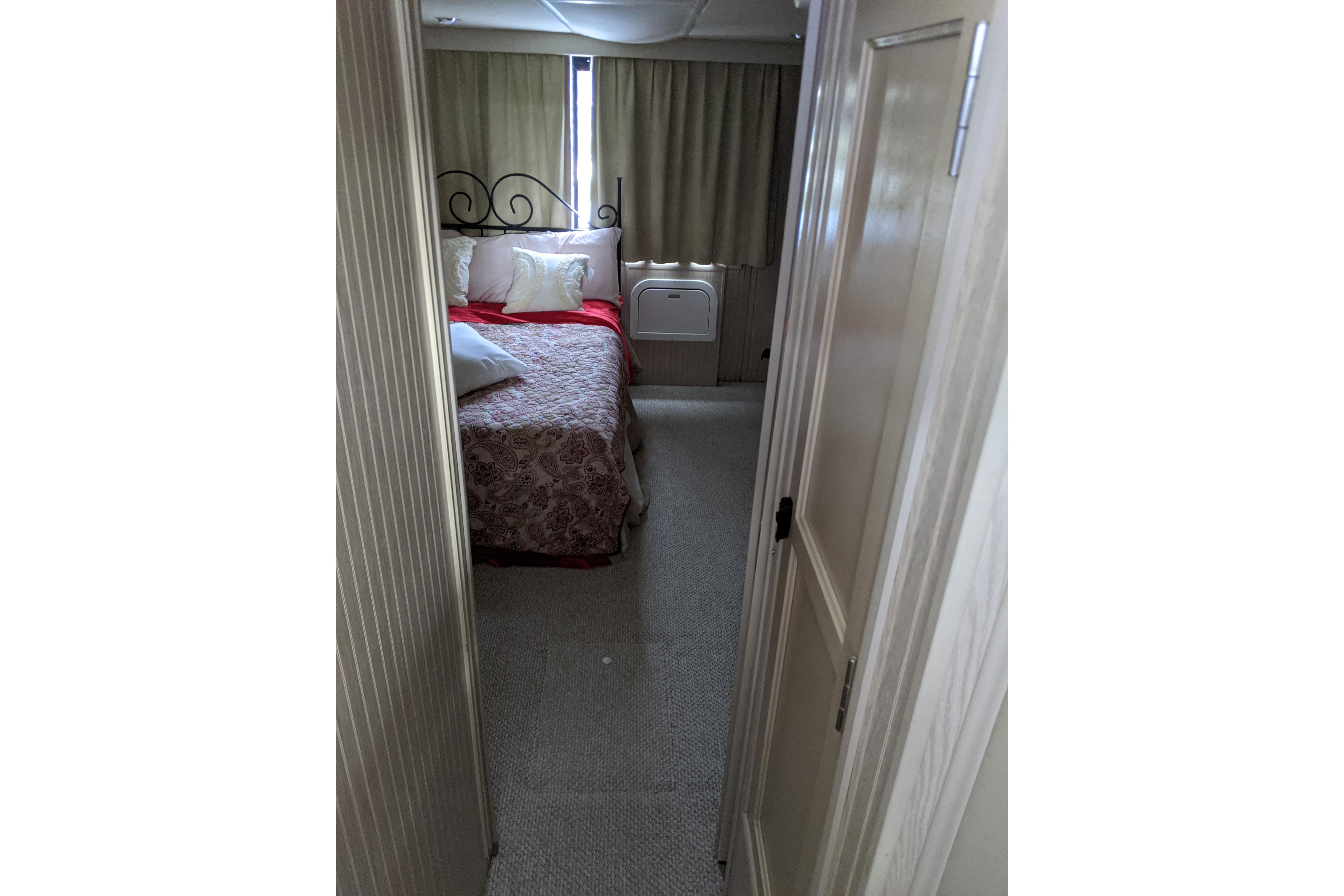 Cozy bedroom interior of 2001 Gibson 50 Cabin Yacht with elegant bedding and curtains.
