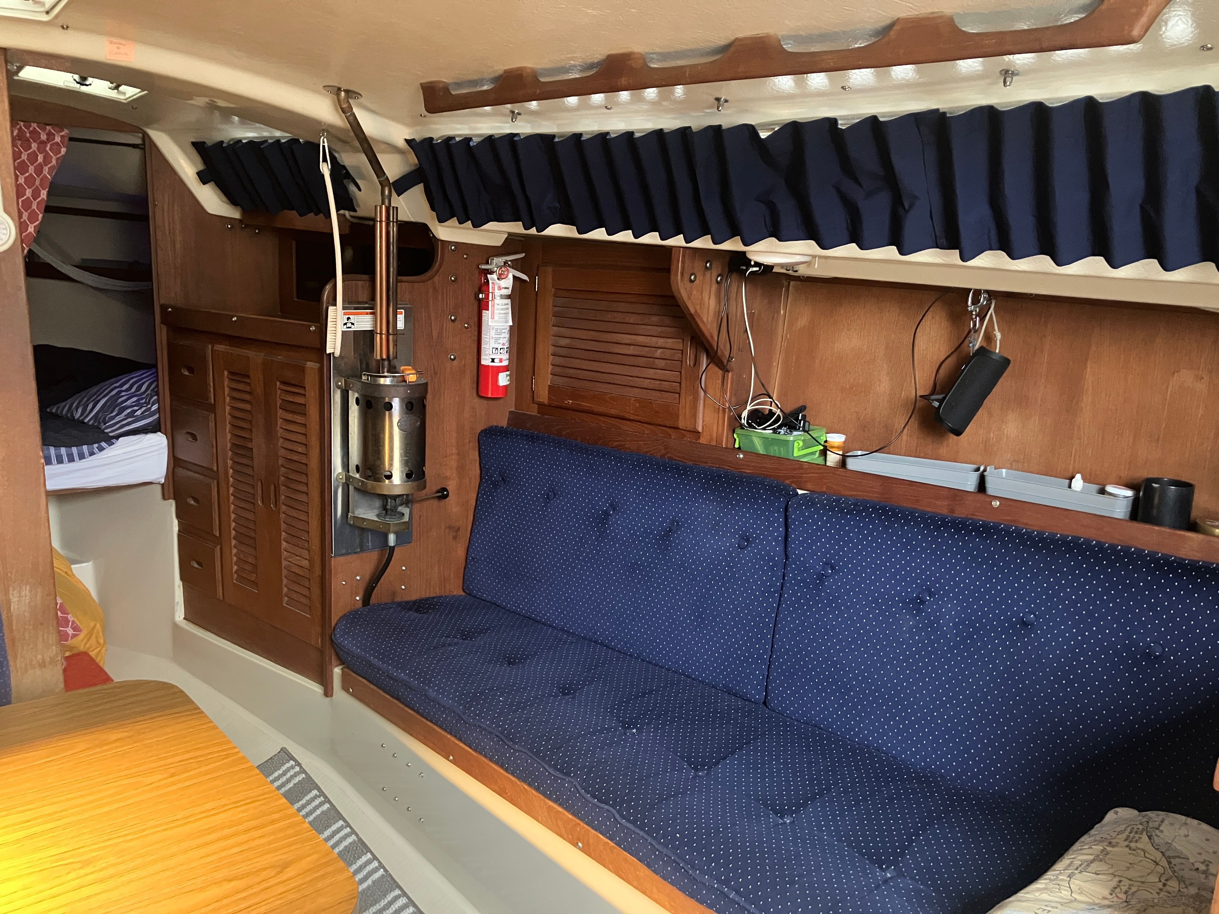 Interior of a 1984 Catalina 30 with blue upholstery and wooden furnishings.