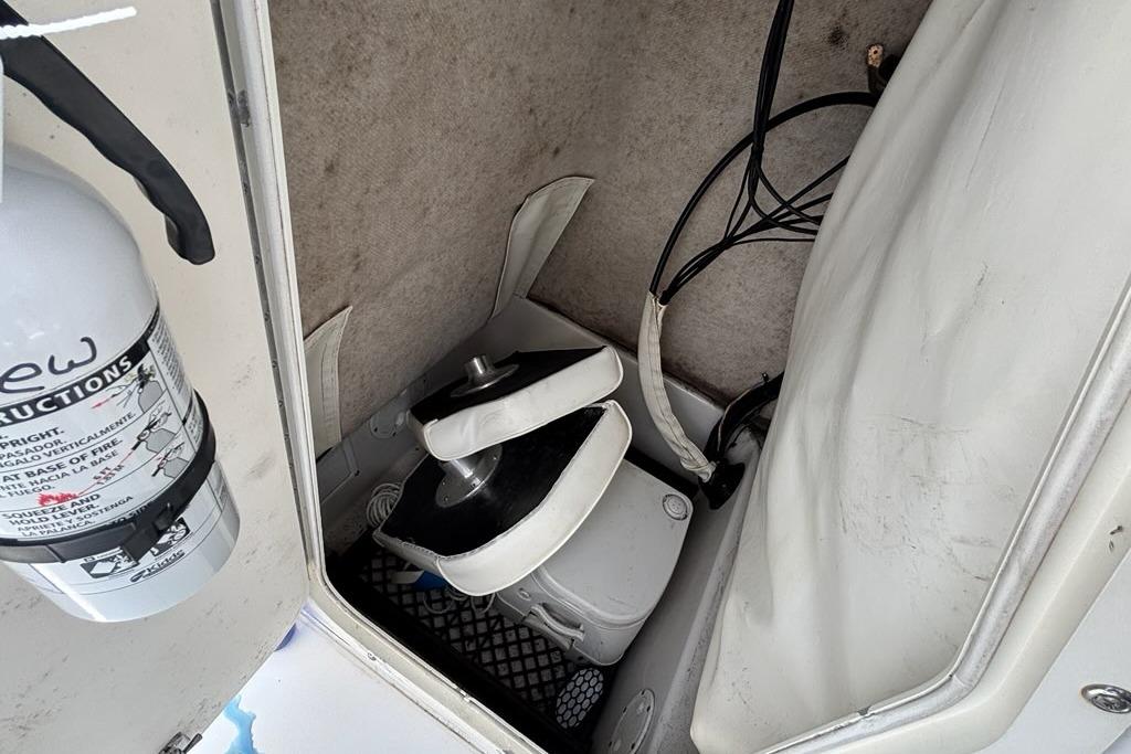 Storage compartment in a 2002 Seaswirl Striper 2101 Center Console boat with fire extinguisher.