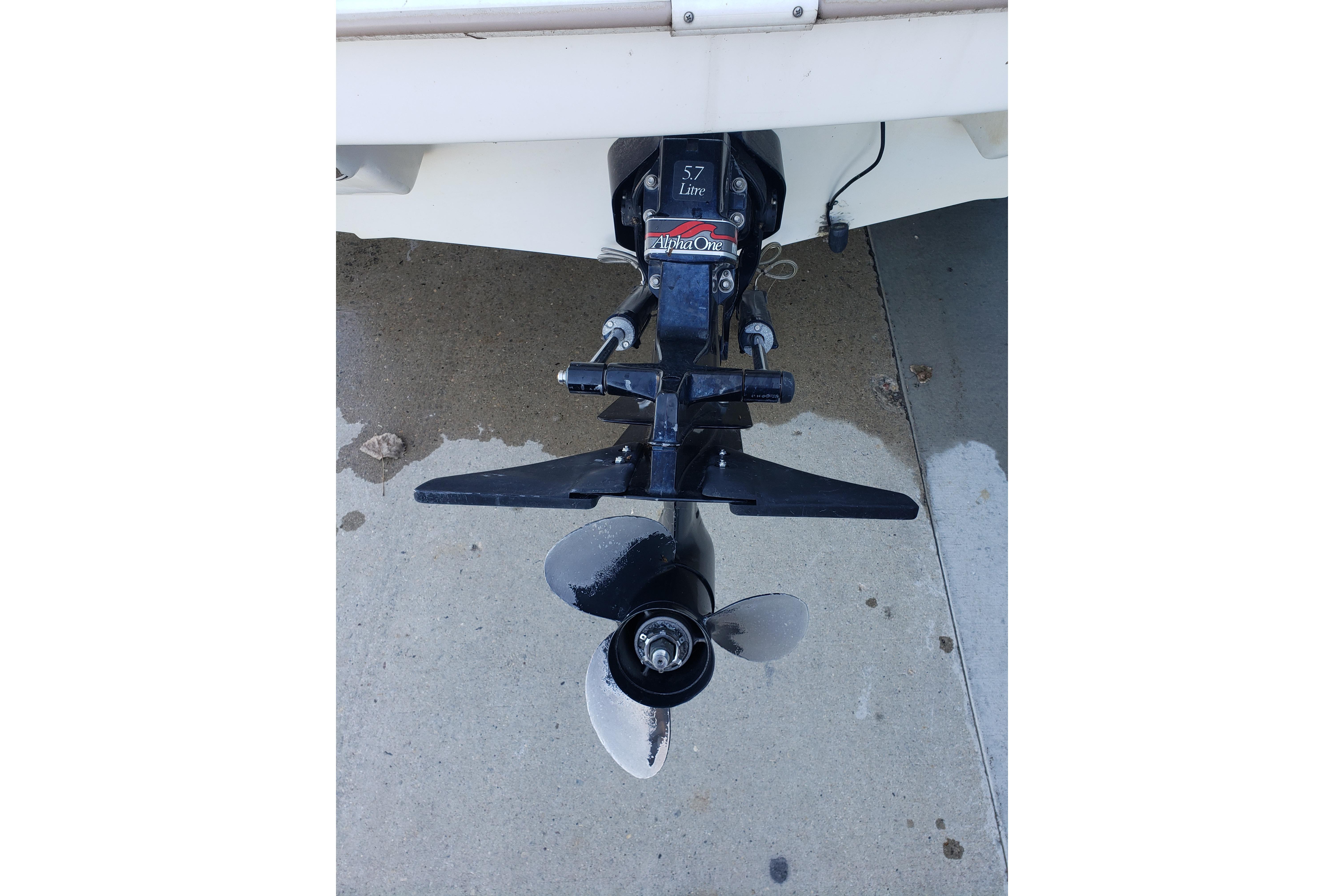 1998 Wellcraft Eclipse 2000 SS boat propeller and outdrive on concrete surface.