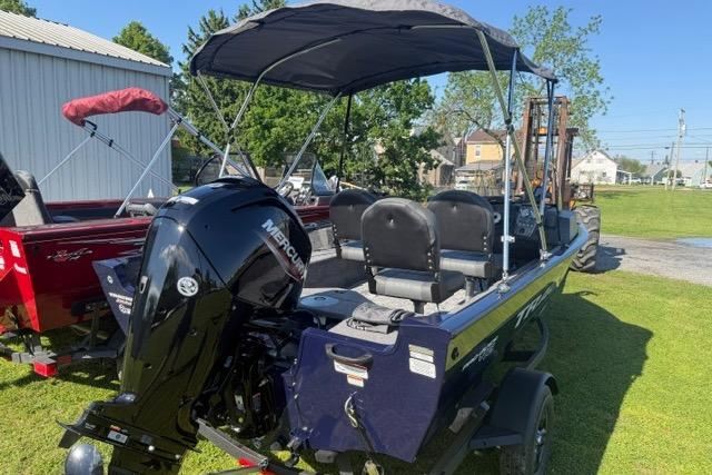 2026 Tracker Pro Guide V-16 SC boat with Mercury engine, parked on grass.