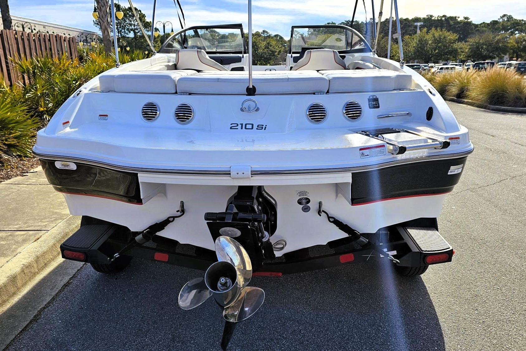 2023 Tahoe 210 Si boat rear view with propeller and trailer on sunny day.