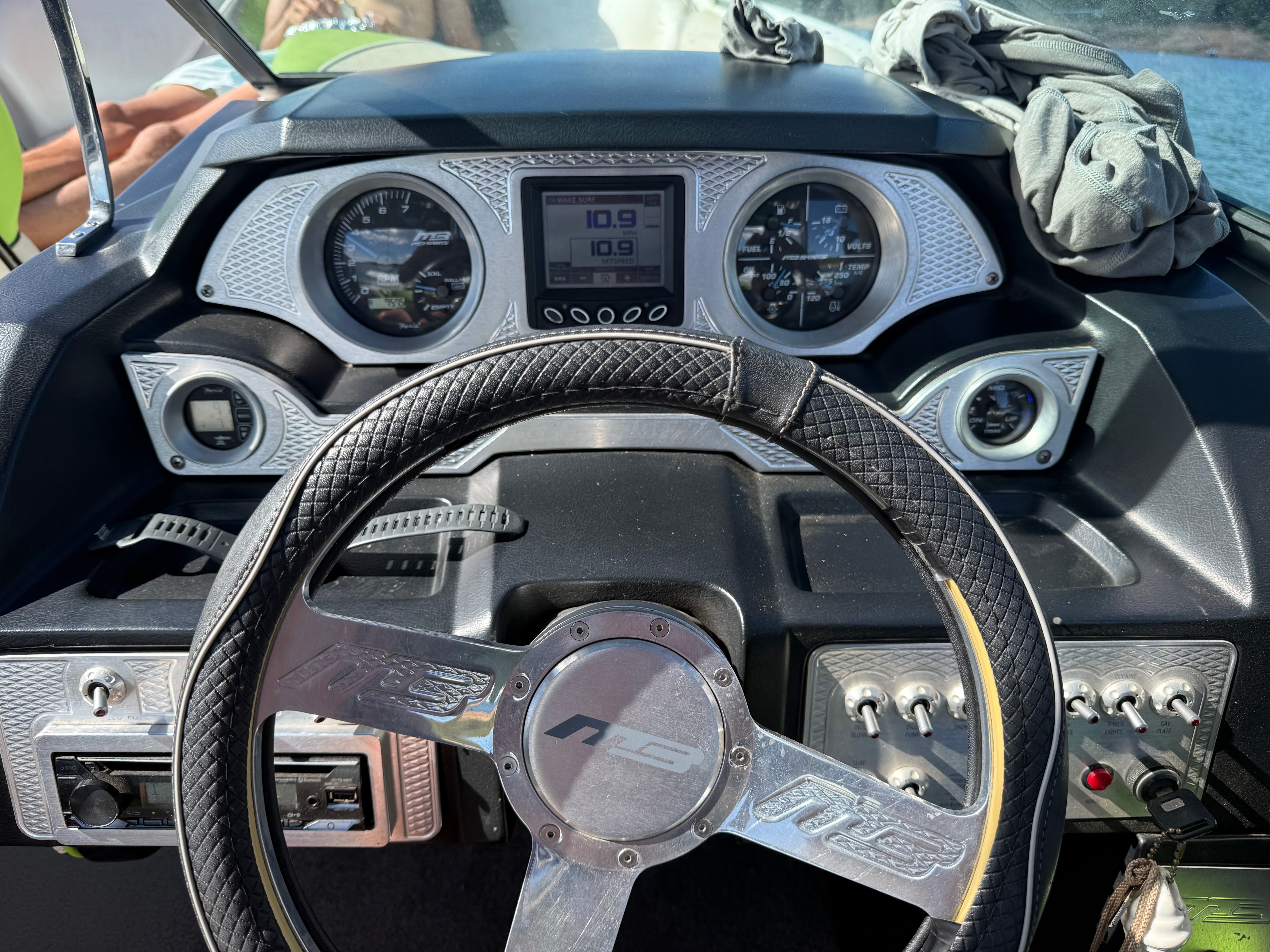 The dashboard of an MB F22 Tomcat boat with steering wheel and instruments.