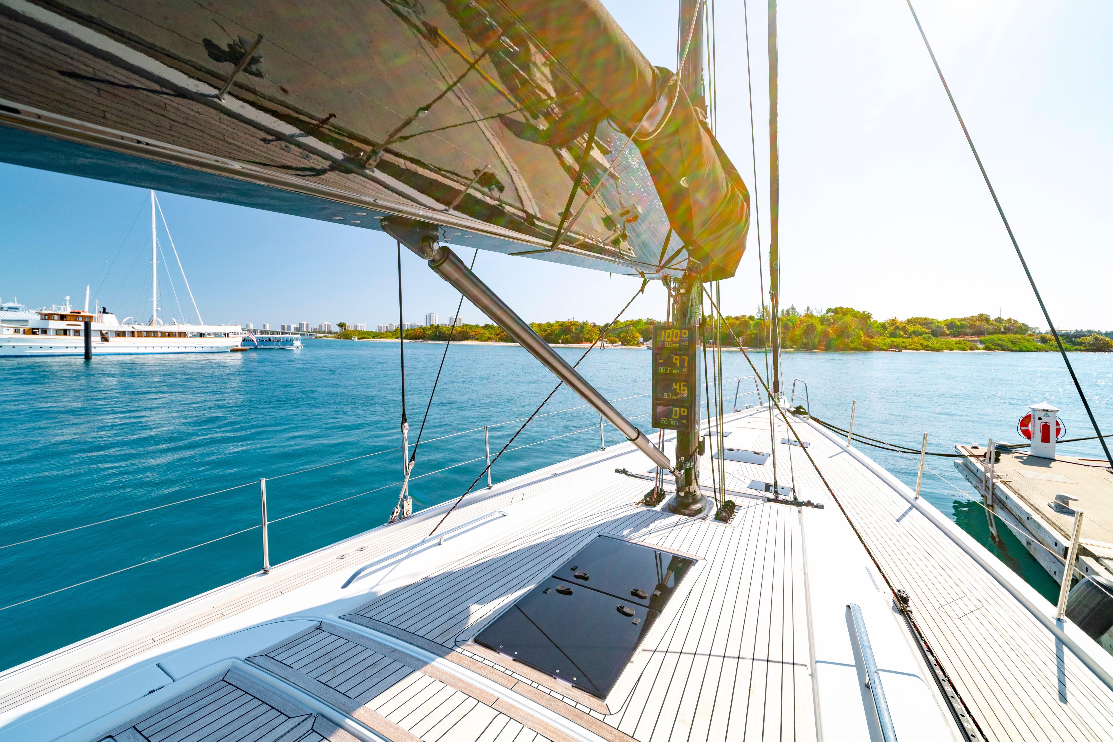 Grand Soleil 58 yacht deck, 2016 model, sailing on clear blue waters near a marina.