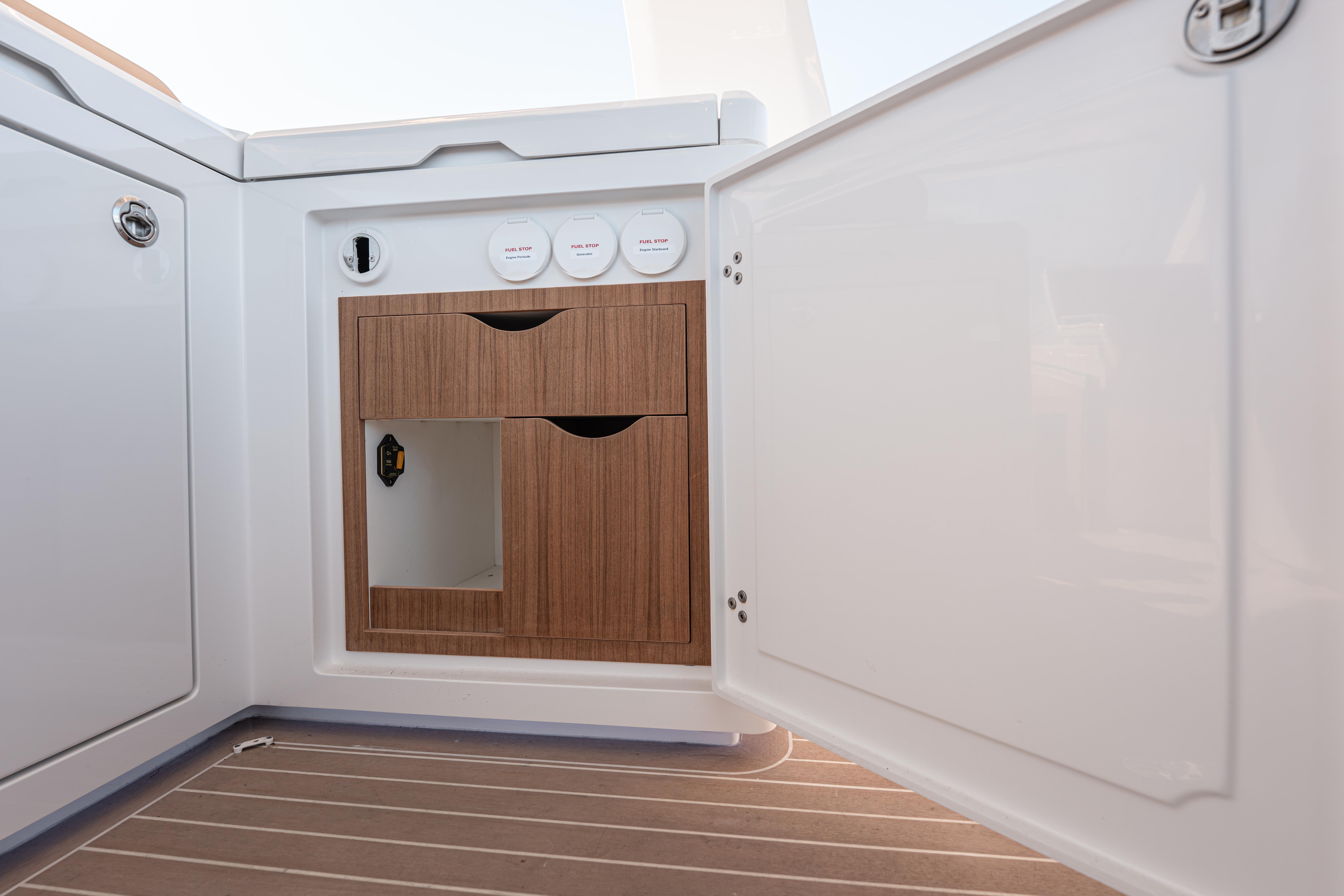 2024 Fjord Boats 53XL interior cabinet with wooden drawers and white paneling.
