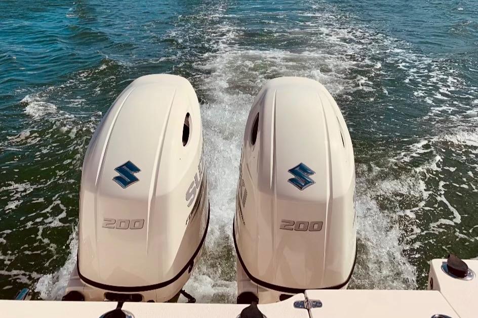 Twin Suzuki outboard engines on a 2019 Sea Chaser 27 HFC boat in motion.