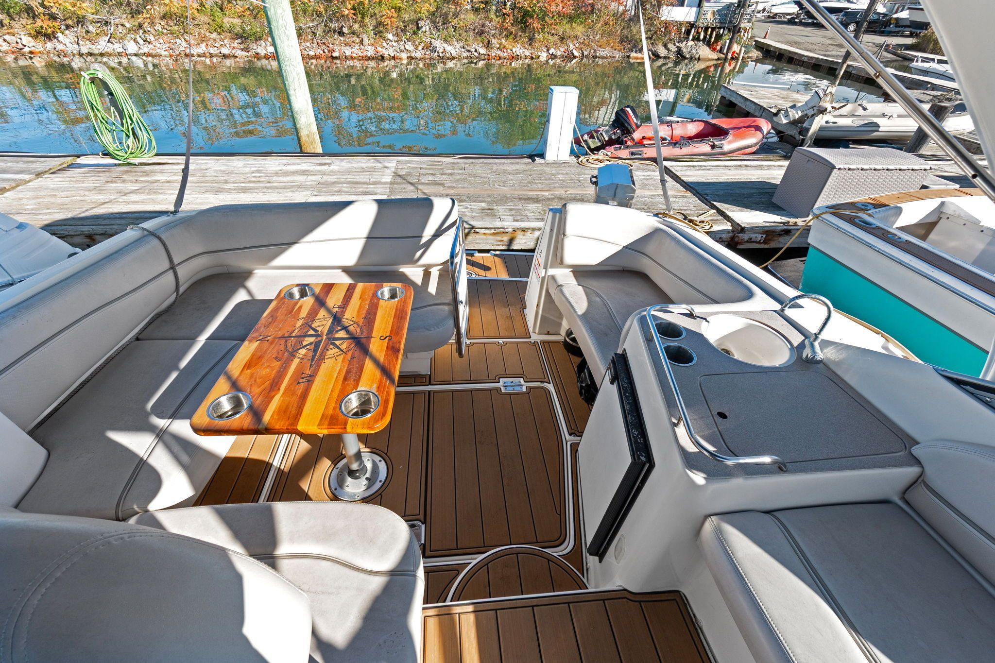 The image shows the cockpit of a 2007 Larson Cabrio 330 with a wooden table and seating.
