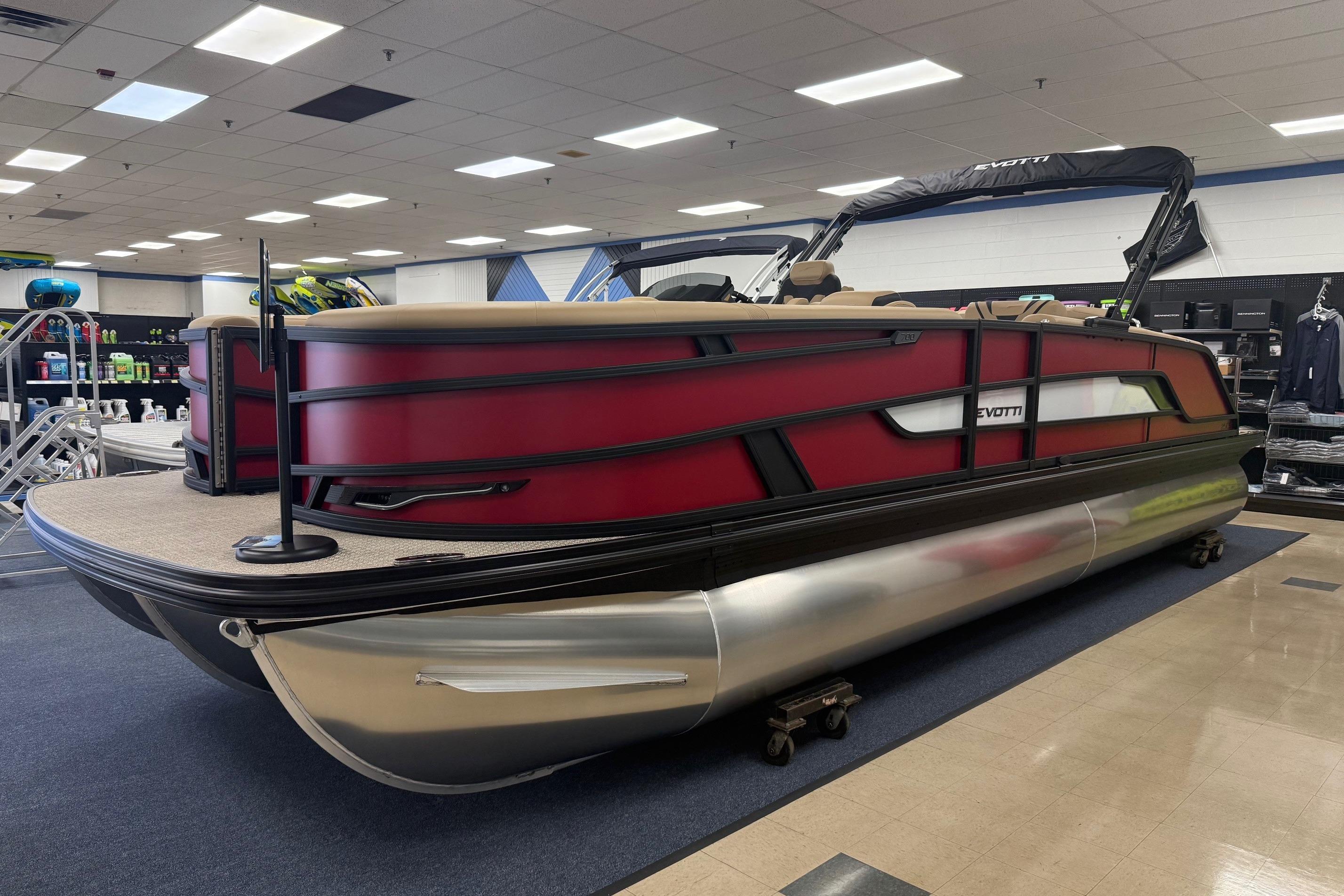 2026 Evotti 725CS pontoon boat displayed indoors, featuring sleek red and black design.