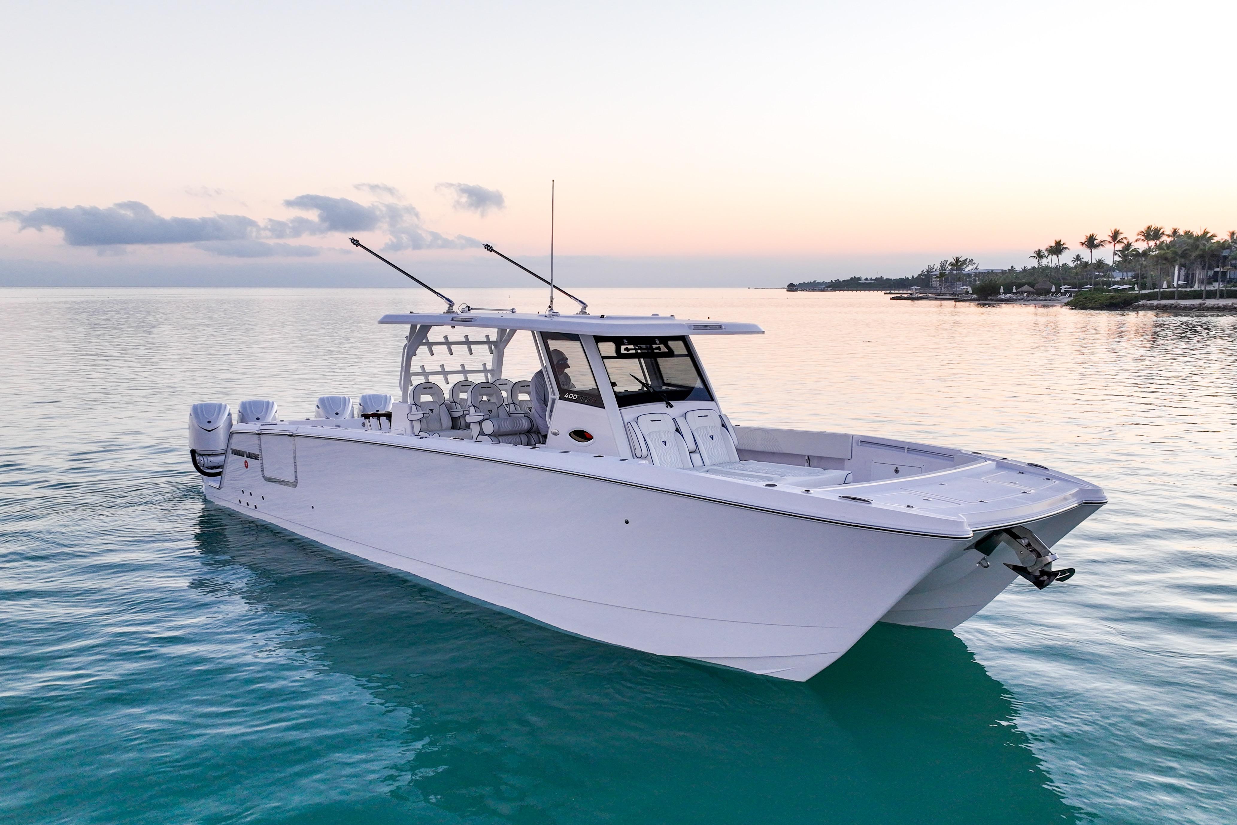 2026 Twin Vee 400 GFX2 CC boat on calm water at sunset.