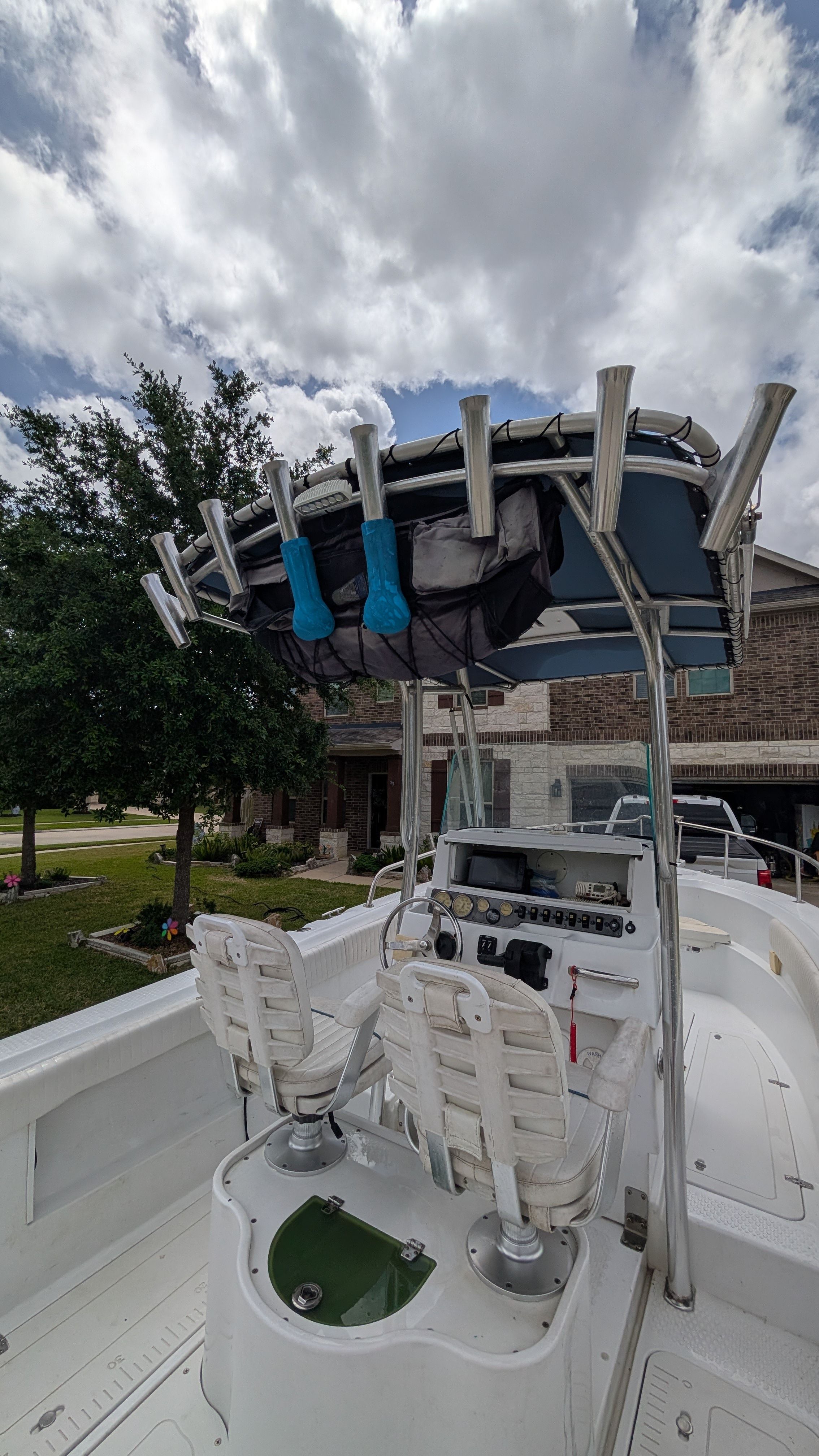 The image shows a 2007 Triumph 215 CC boat with a helm station and fishing rod holders.
