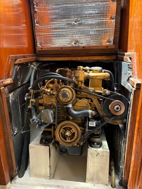 The engine compartment of a 1989 Catalina 34 shows a well-maintained engine with hoses and belts.