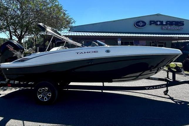 2025 Tahoe T18 boat on trailer outside dealership, side view.