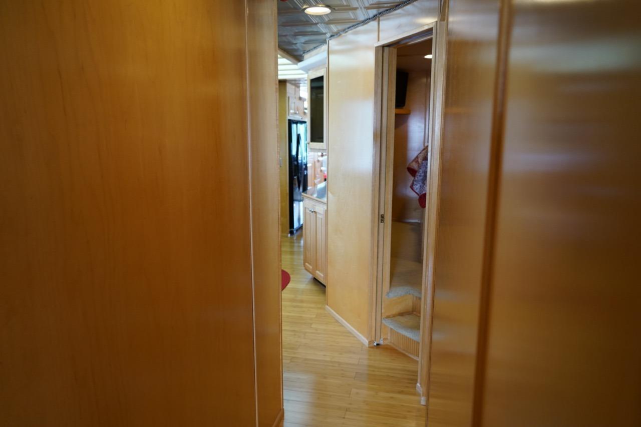 Interior hallway of a 2000 Stardust Cruisers 83'x17' houseboat, featuring wooden paneling and modern design.