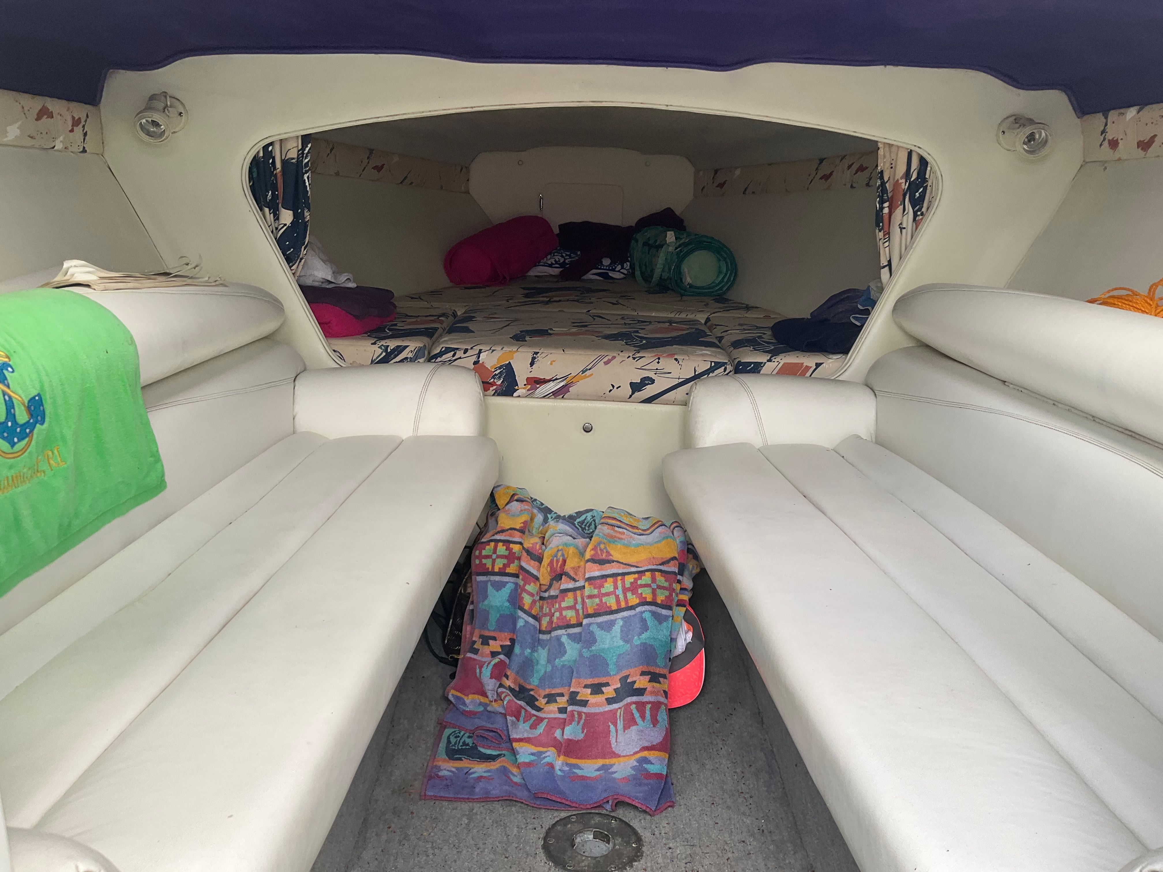 Interior of a 1995 Baja Caliber with white seating and sleeping area.