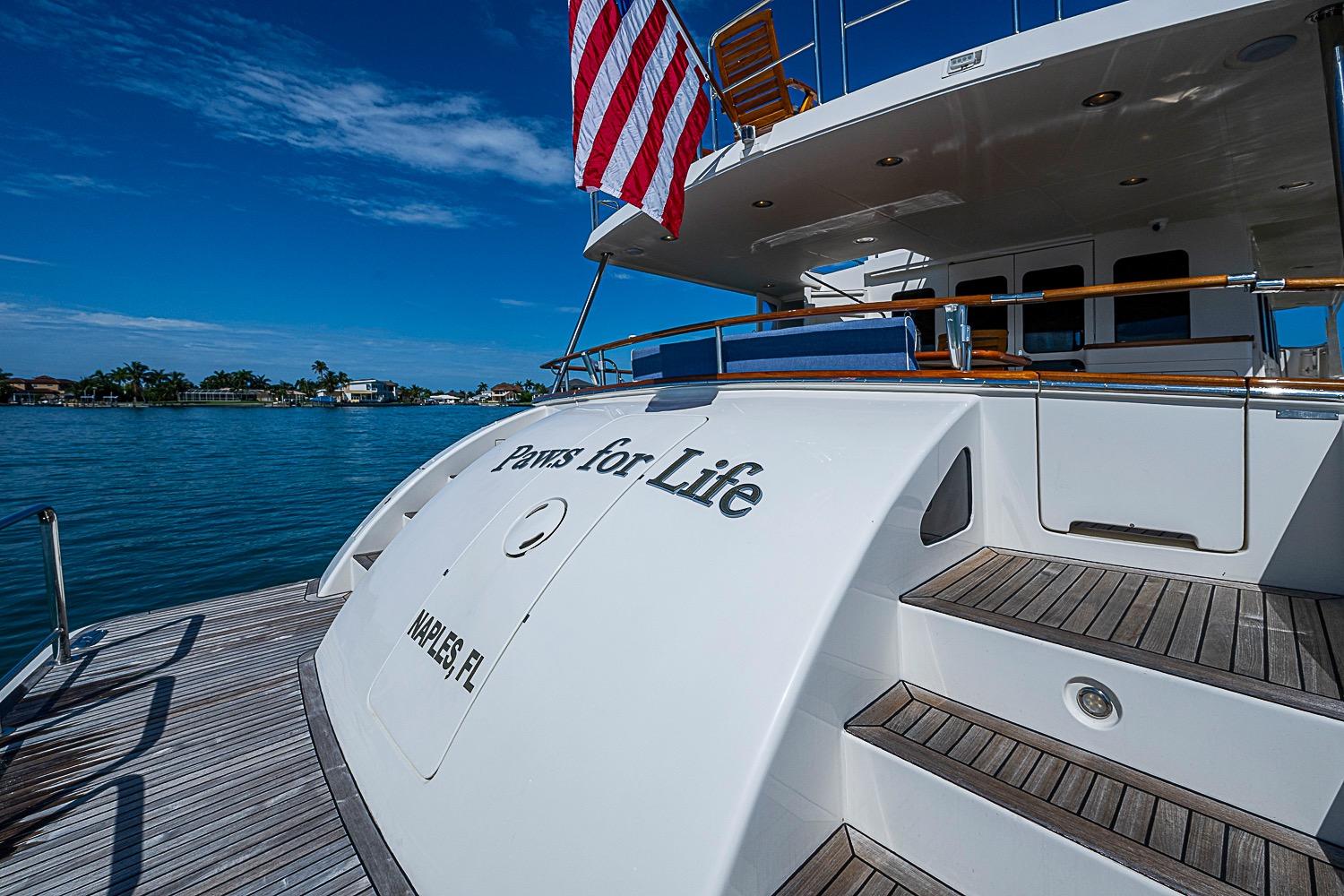 Luxury 2014 Marlow 80 Explorer yacht docked, featuring "Paws for Life" and American flag.