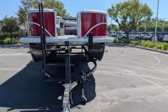 2026 Sun Tracker Party Barge 20 DLX pontoon boat on trailer in parking lot.