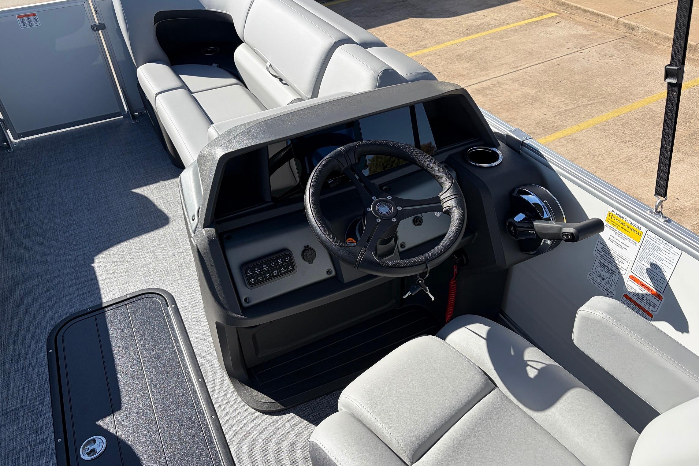 2026 Sun Tracker Party Barge 22 RF XP3 boat interior with steering wheel and seating.