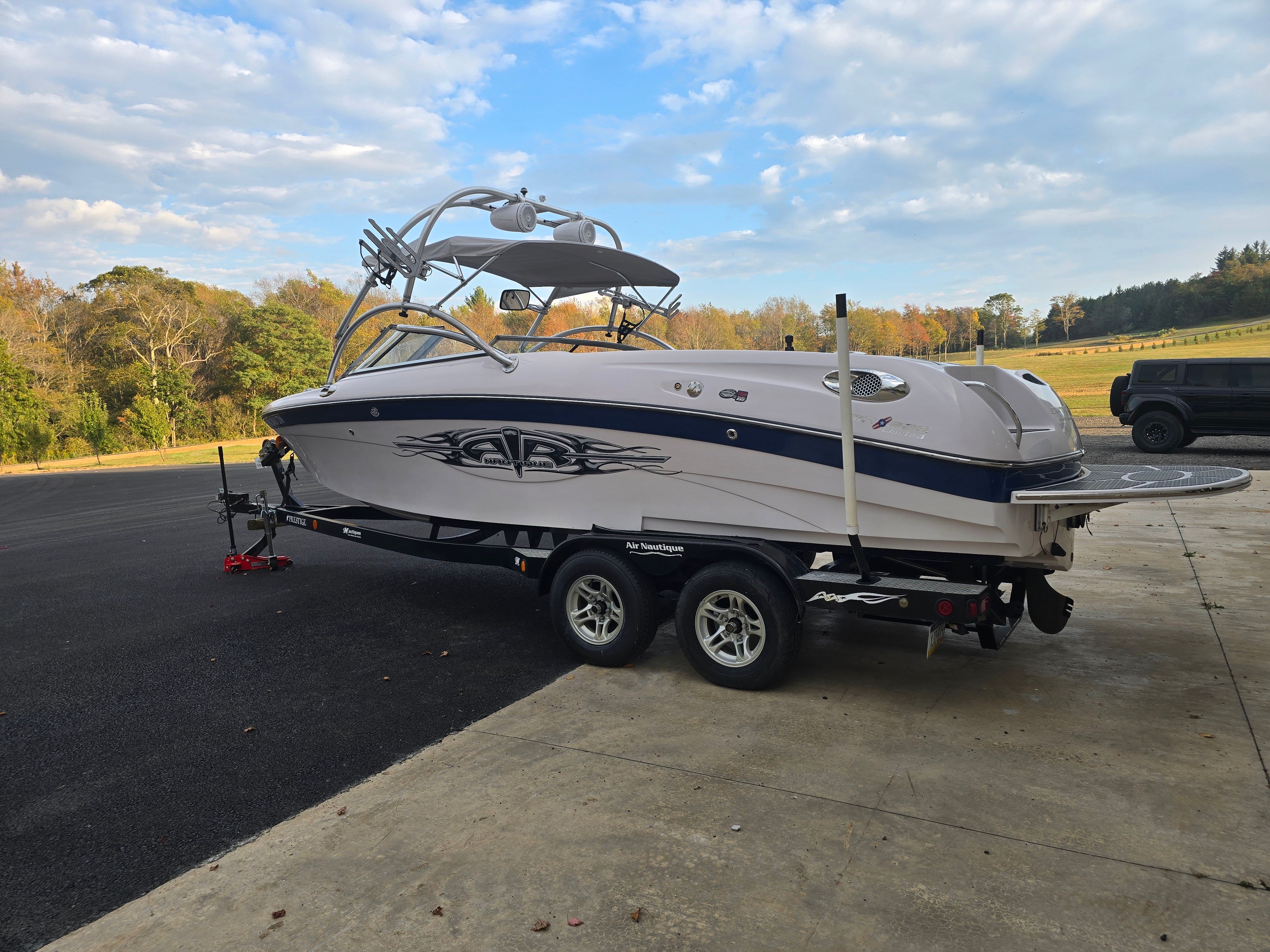 2006 Correct Craft 228 boat on trailer, parked outdoors.