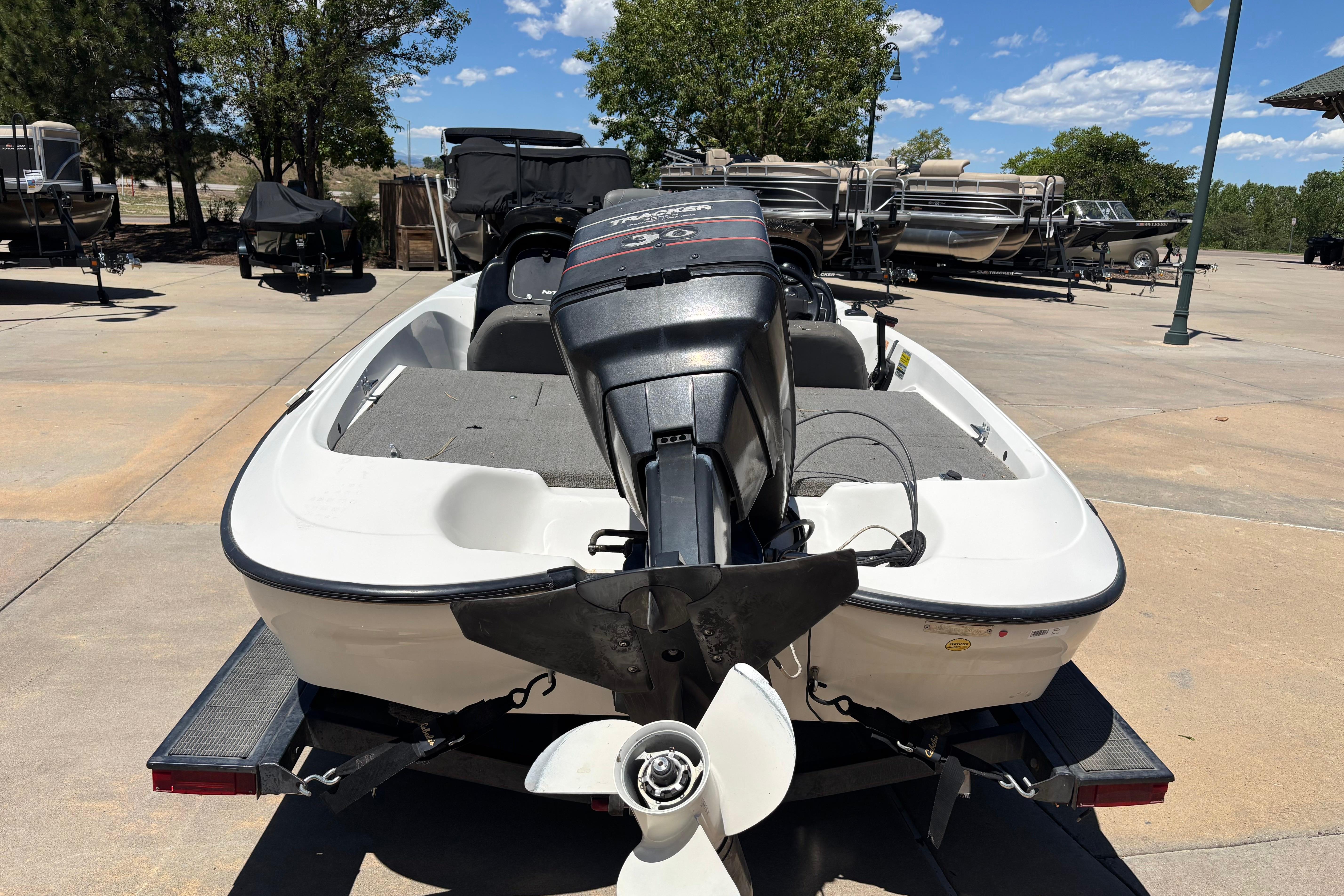 1998 Nitro 700 LX DC boat with outboard motor on trailer, parked outdoors.