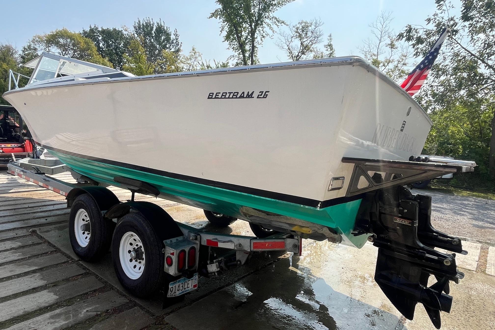 1975 Bertram 26 Moppie boat on trailer, displayed outdoors with American flag.