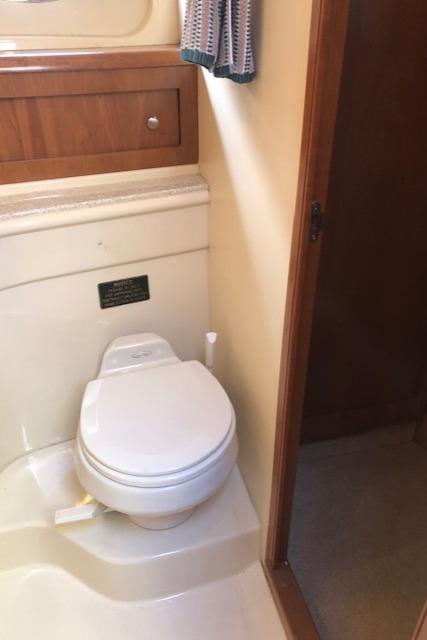 2003 Meridian 411 yacht bathroom with toilet and wooden cabinetry.