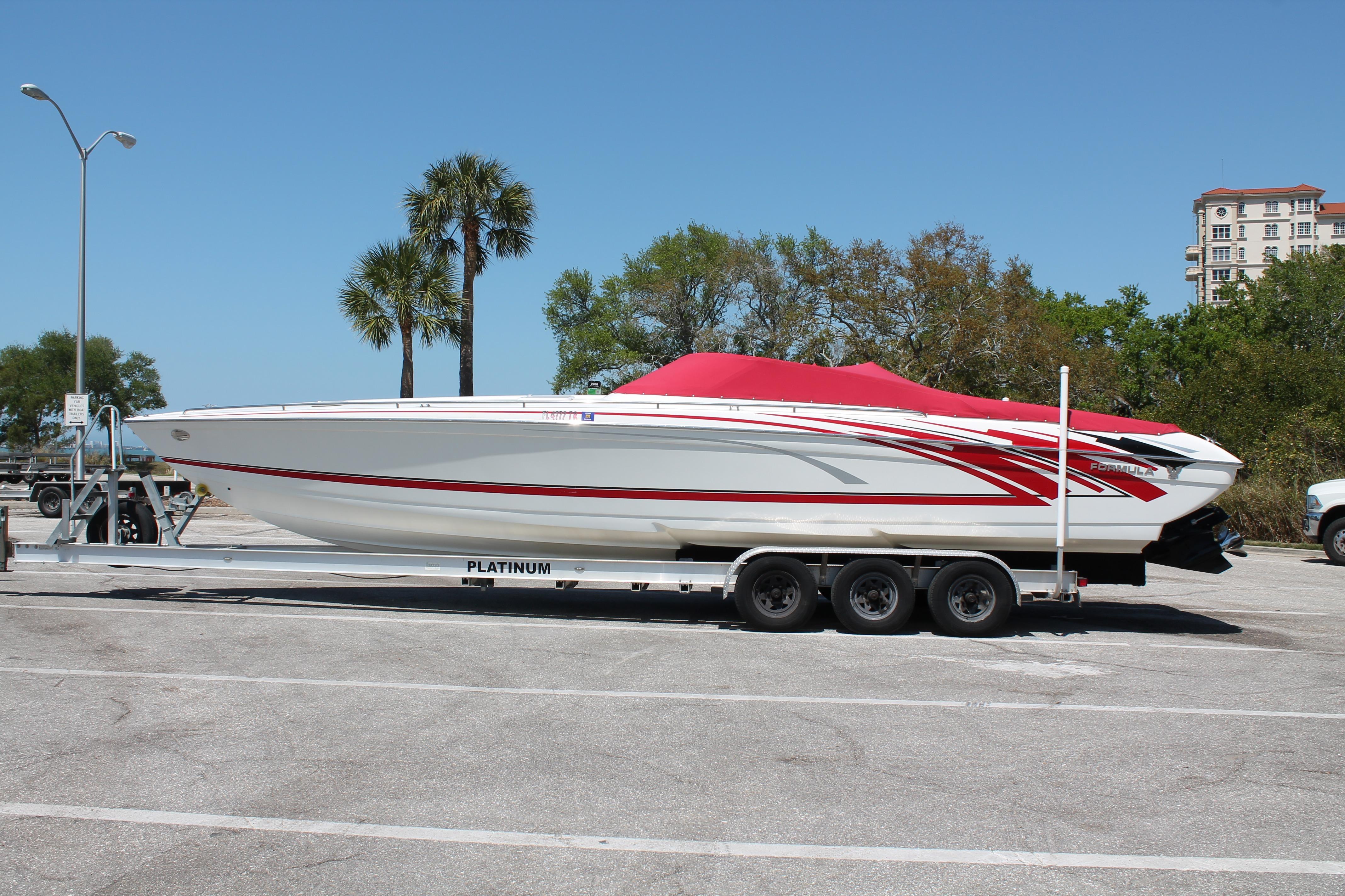 2016 Formula 353 FASTech boat on trailer, red and white design, parked outdoors.