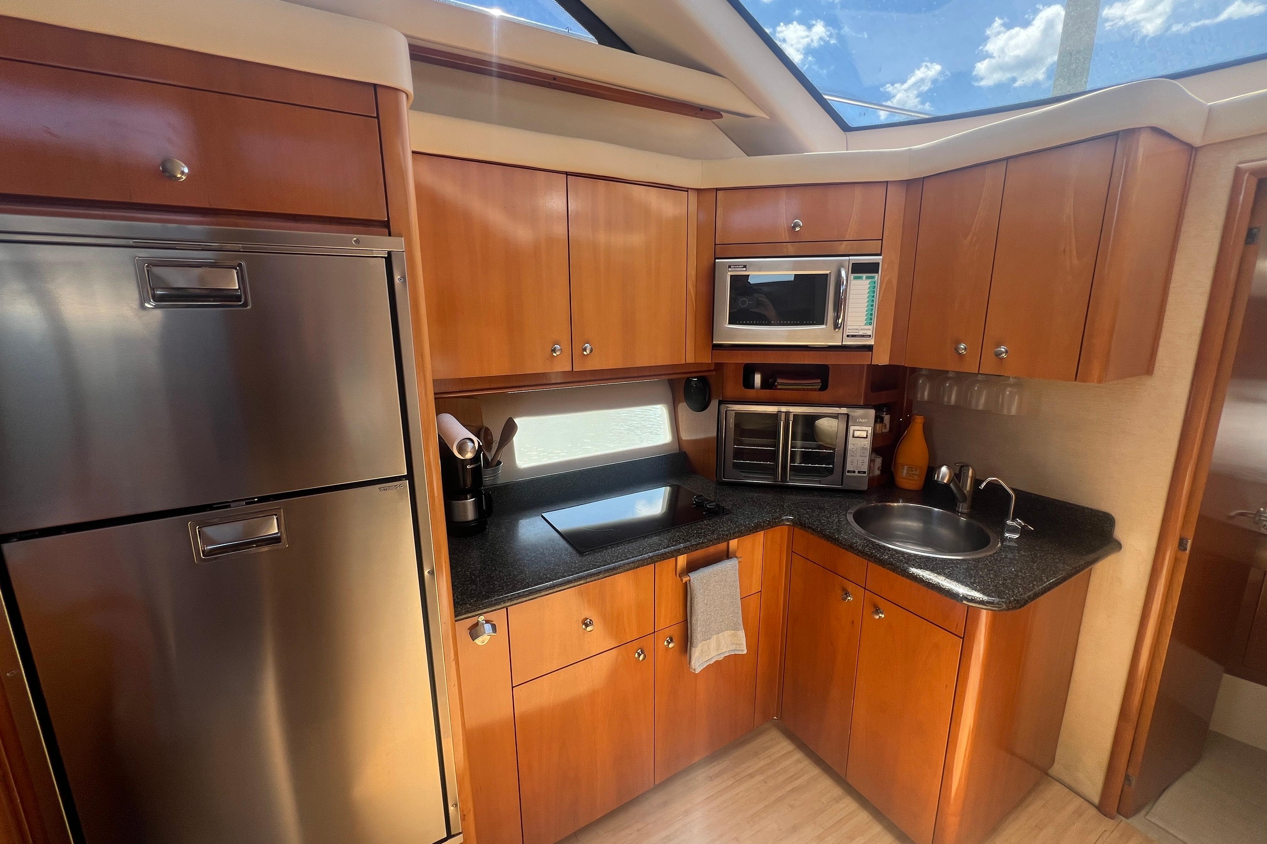 Interior of 2006 Carver 43 Motor Yacht kitchen with wood cabinets and stainless steel appliances.